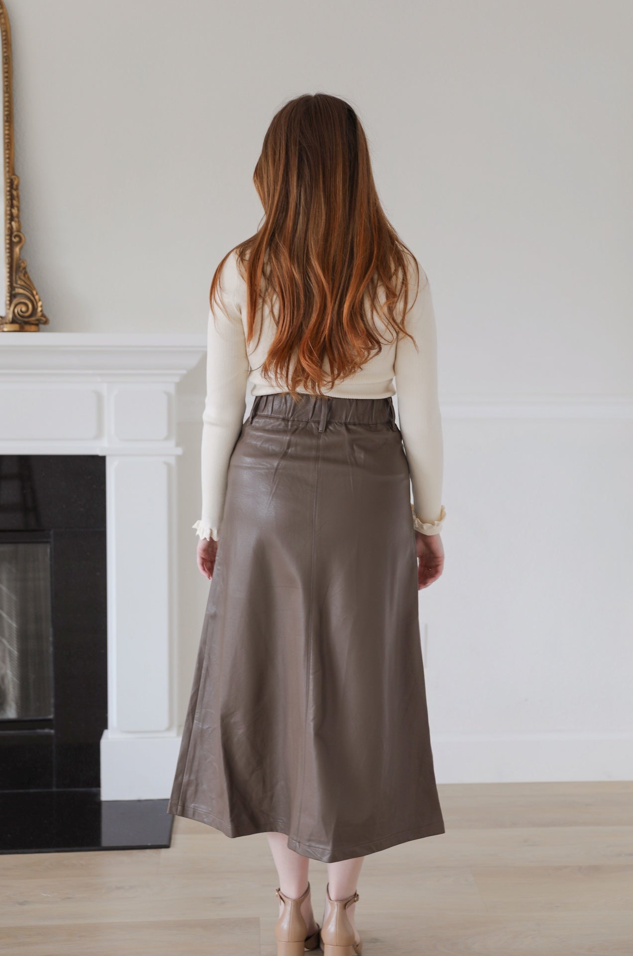 brown faux leather midi skirt that is high waisted with pockets
