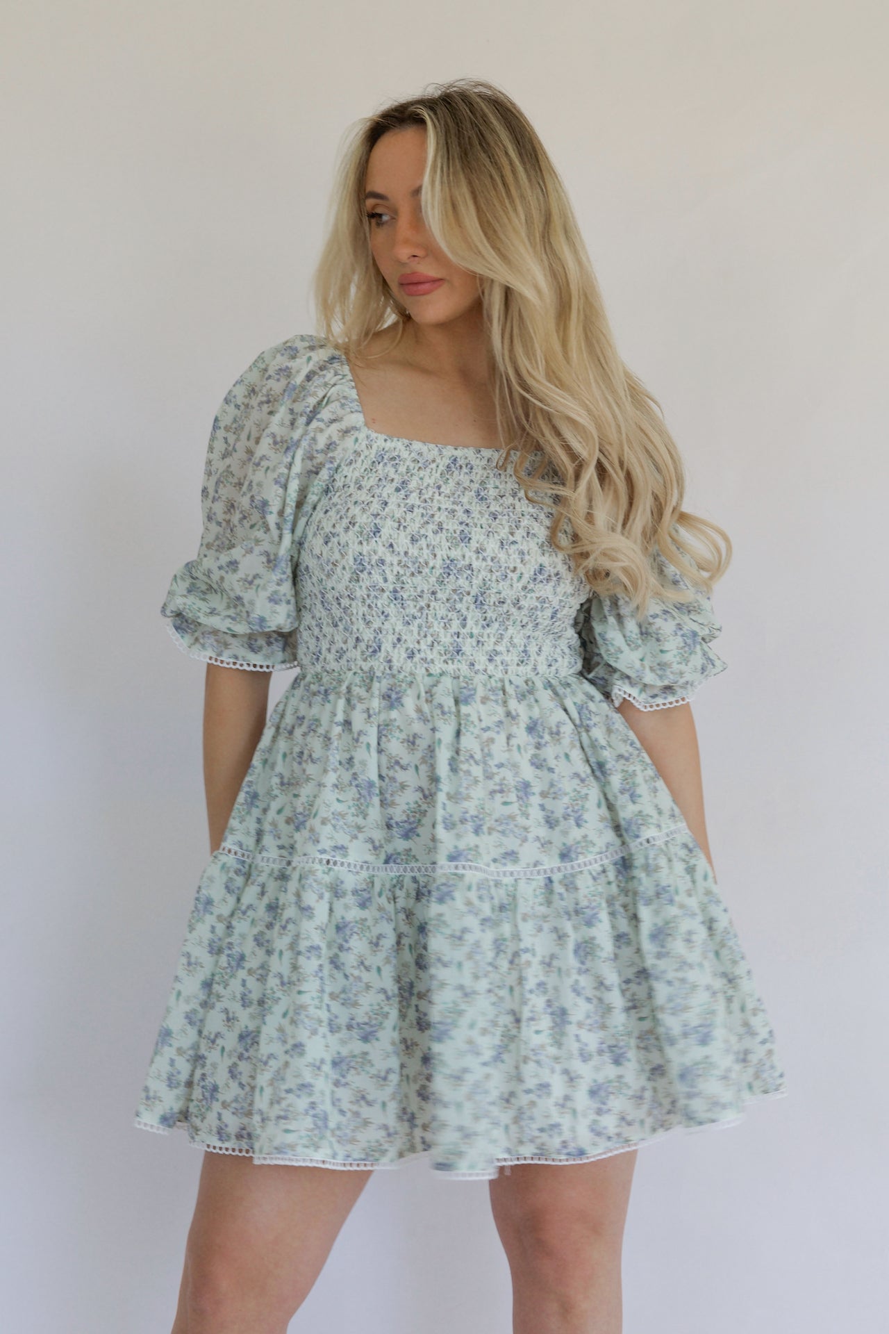 blue floral mini dress with puff sleeves, tiered, and crochet lace trim