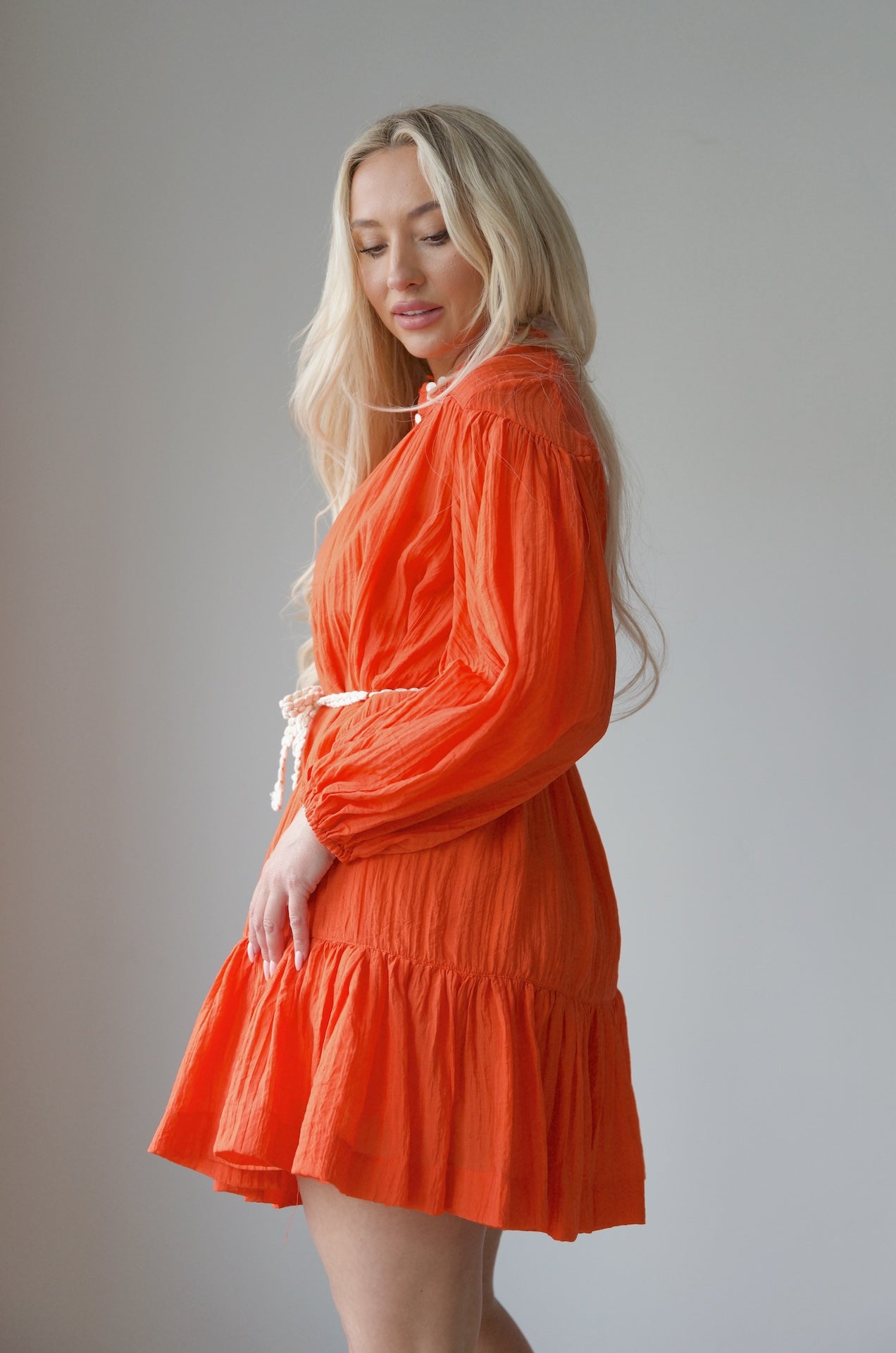orange long sleeve mini dress with a braided belt