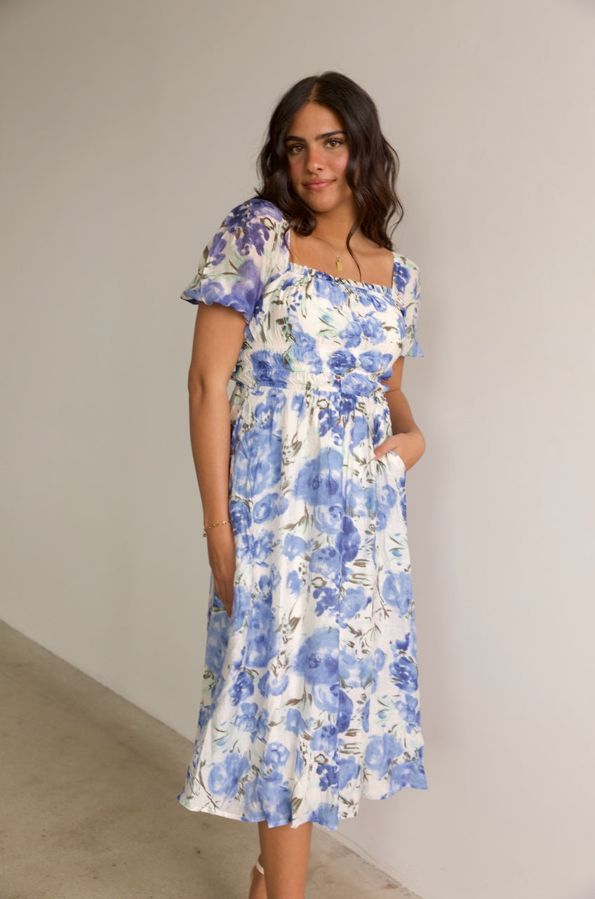 blue and white floral midi dress with puff sleeves and a square neckline