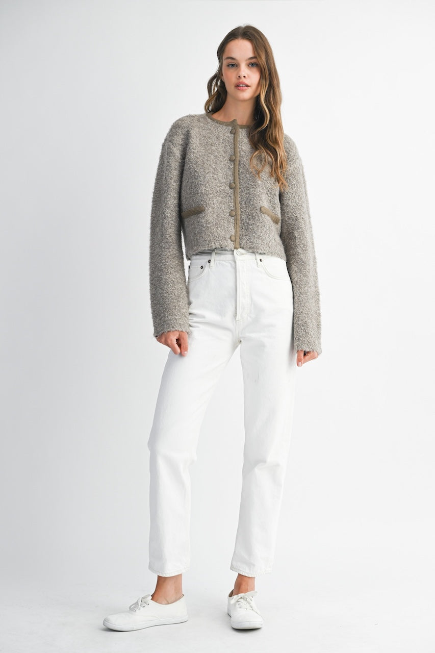 Woman wearing a brown knitted texture boucle jacket with brown buttons