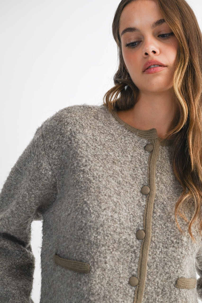 Woman wearing a brown knitted texture boucle jacket with brown buttons
