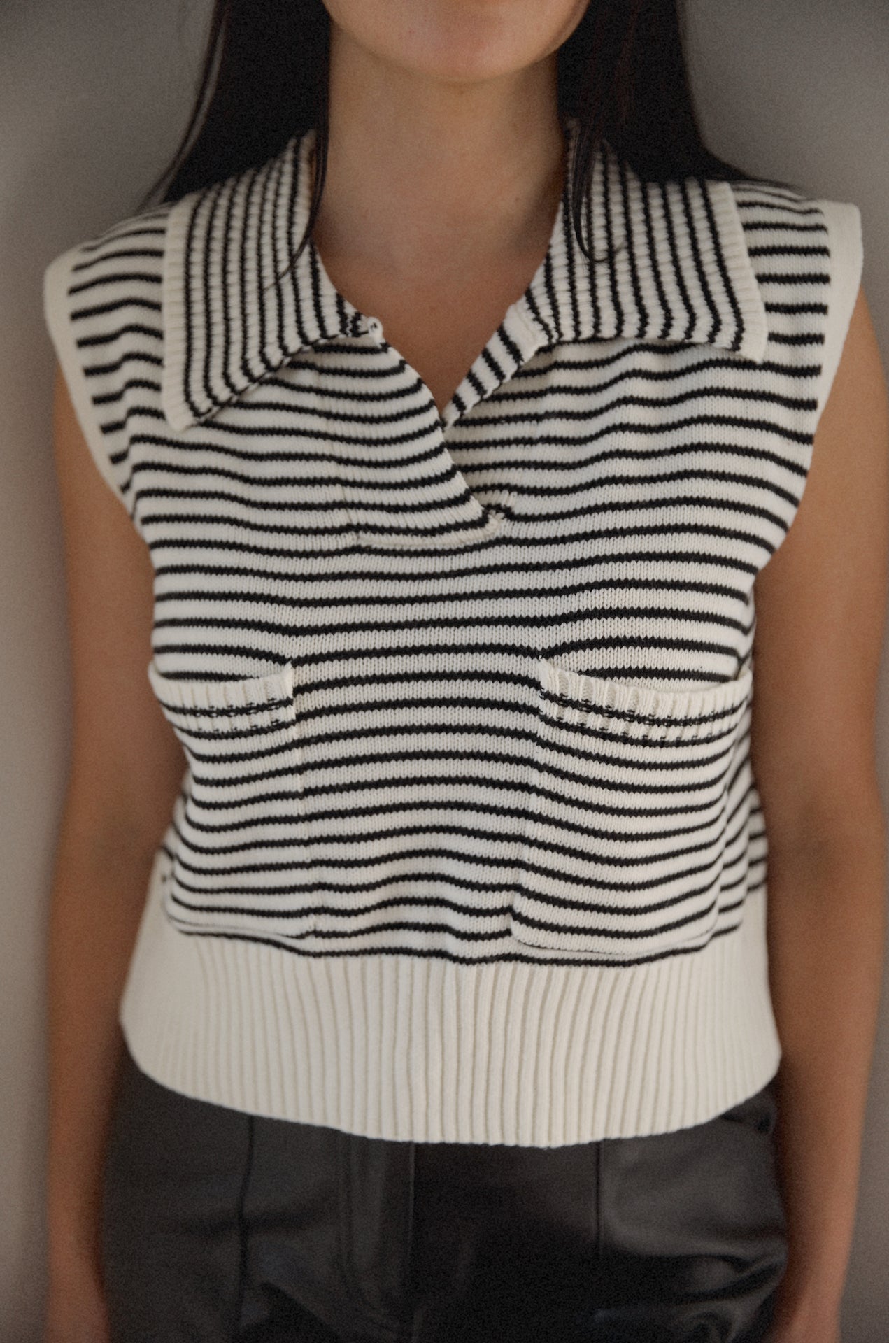 black and white striped sweater vest that is collared with pockets