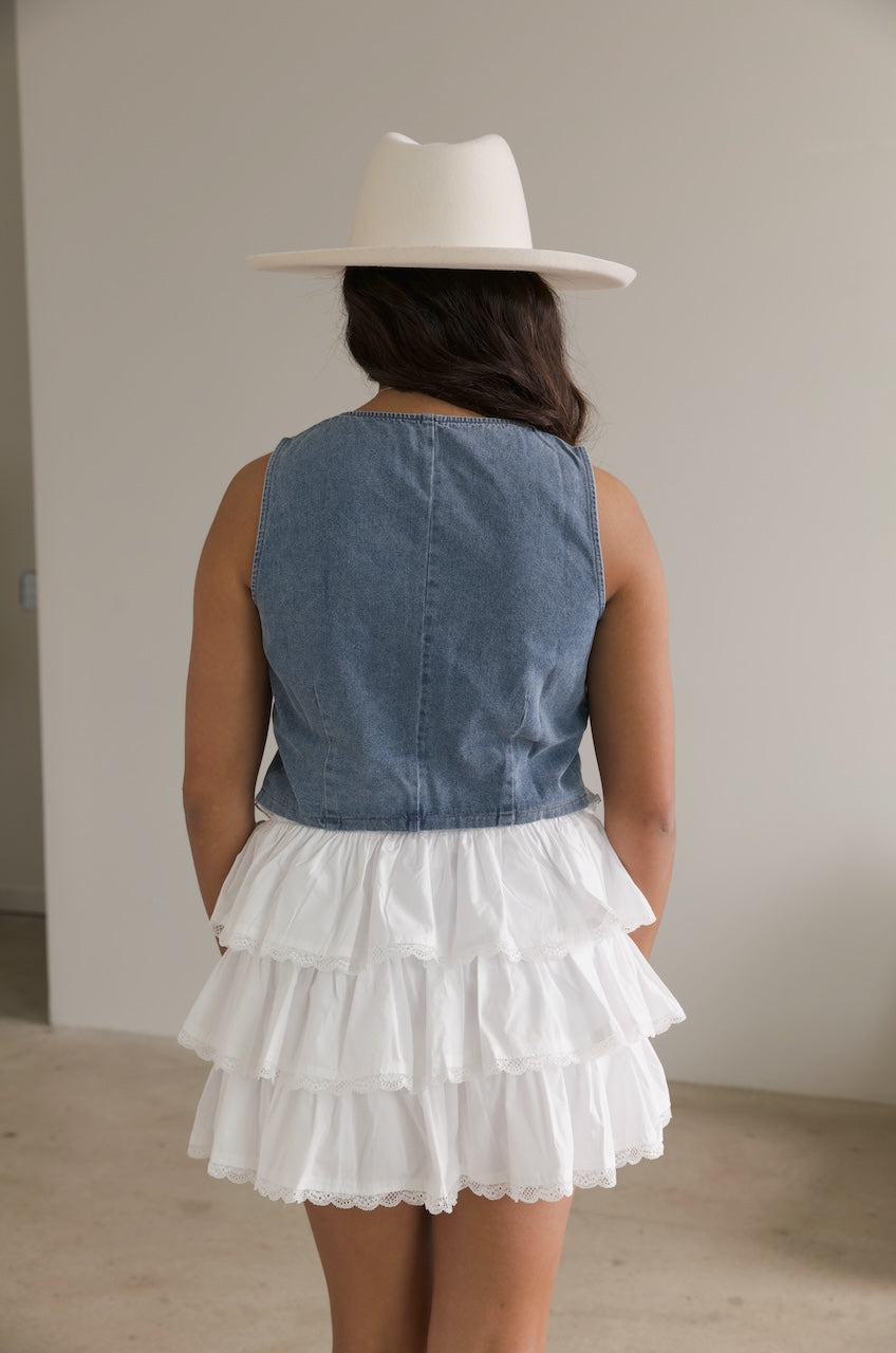denim bow tie vest top paired with a white ruffle mini skirt