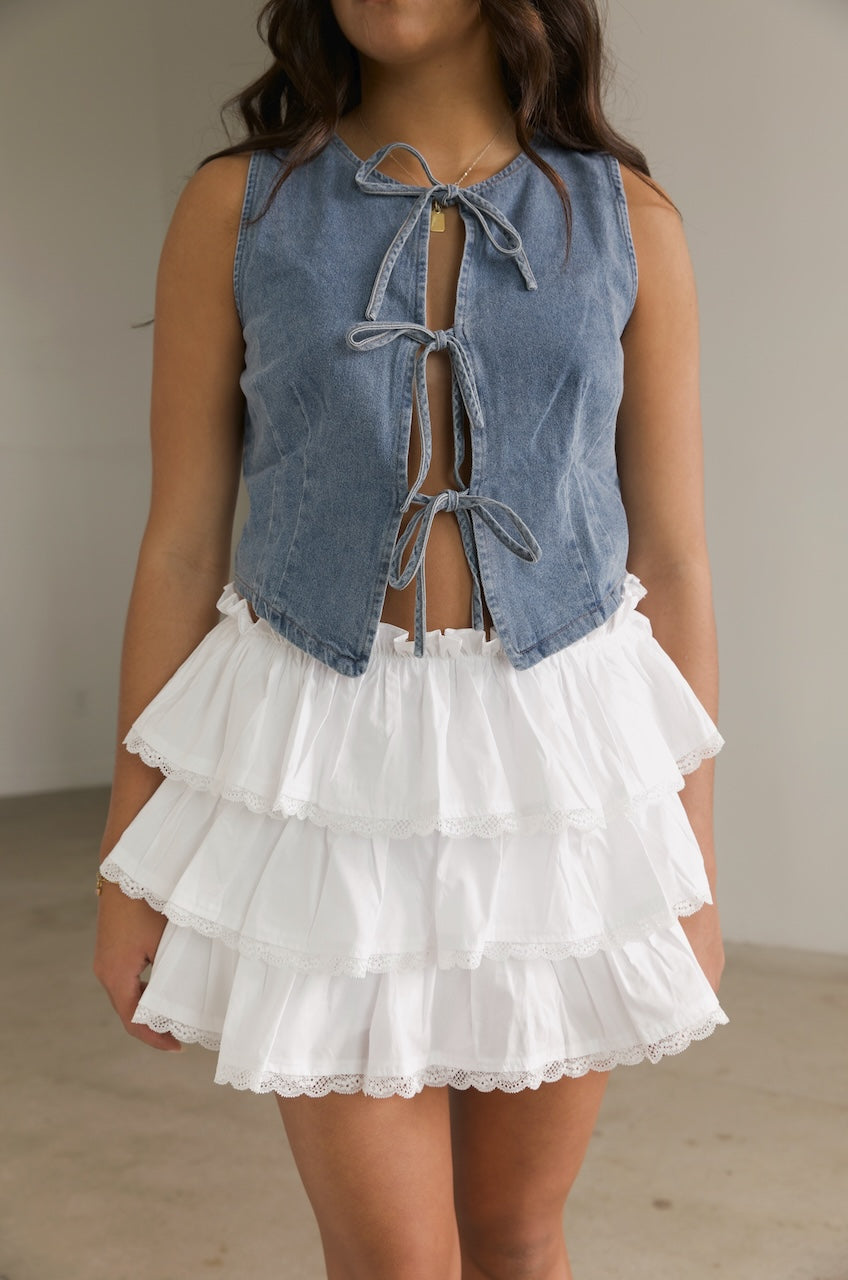 denim bow tie vest top paired with a white ruffle mini skirt