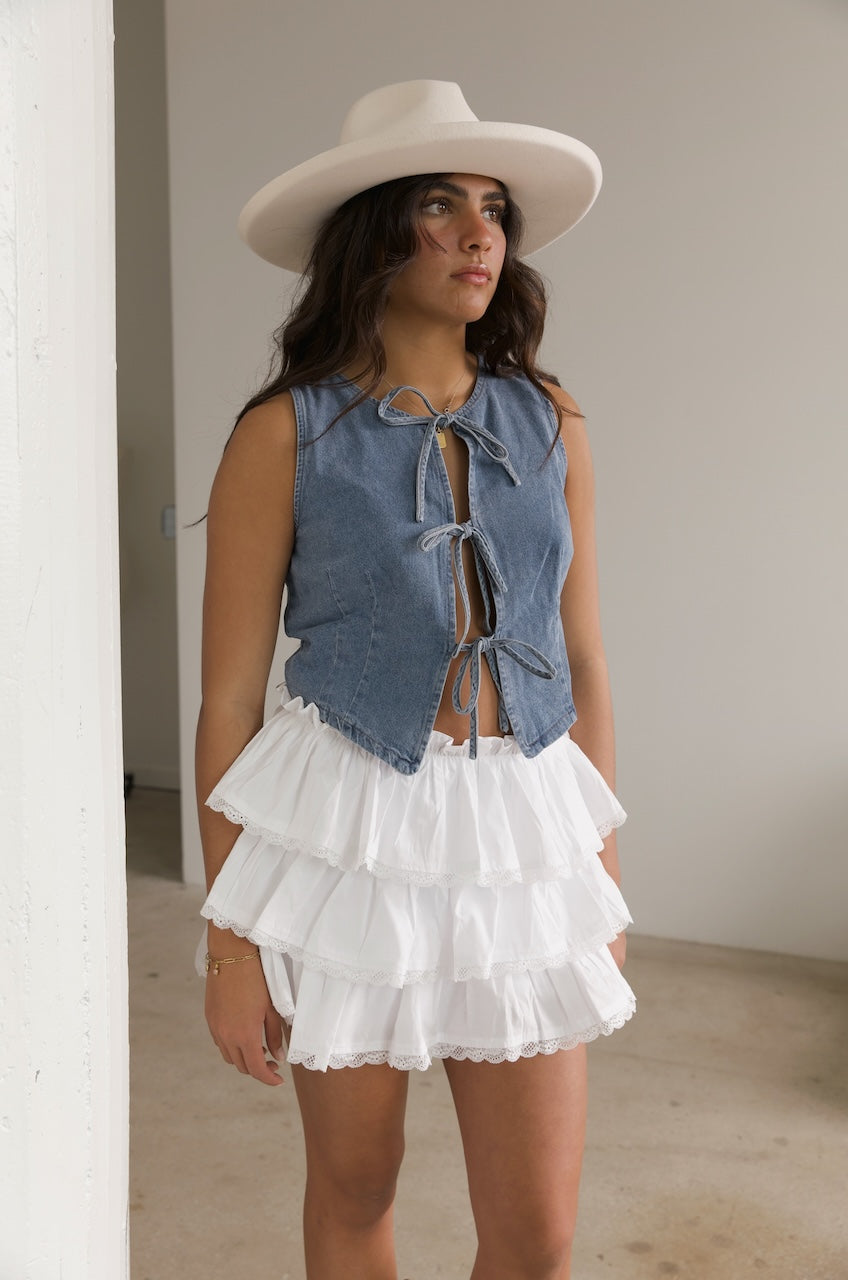 denim bow tie vest top paired with a white ruffle mini skirt
