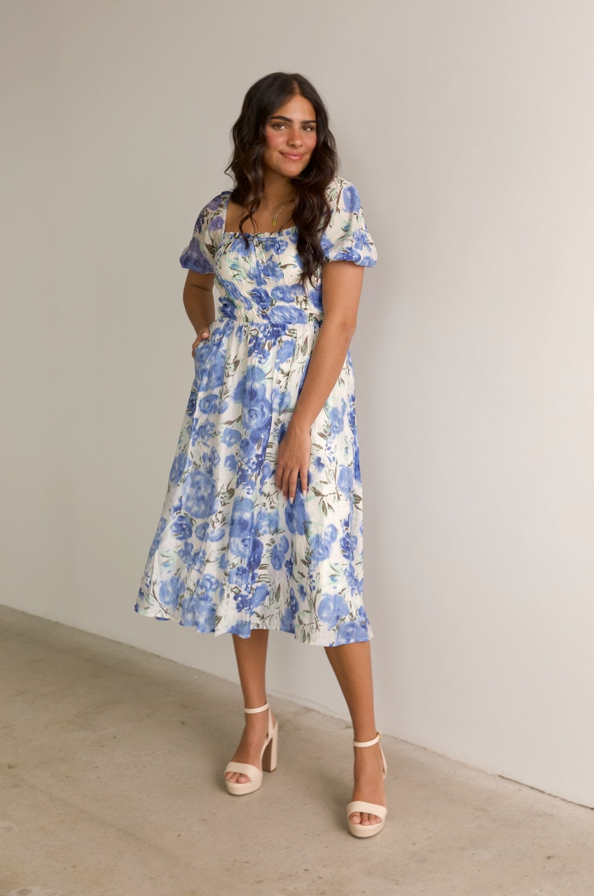 blue and white floral midi dress with puff sleeves and a square neckline