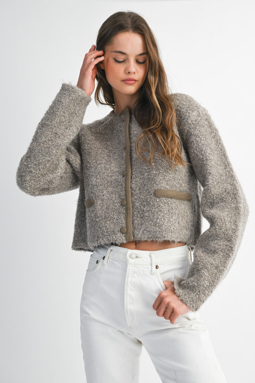 Woman wearing a brown knitted texture boucle jacket with brown buttons
