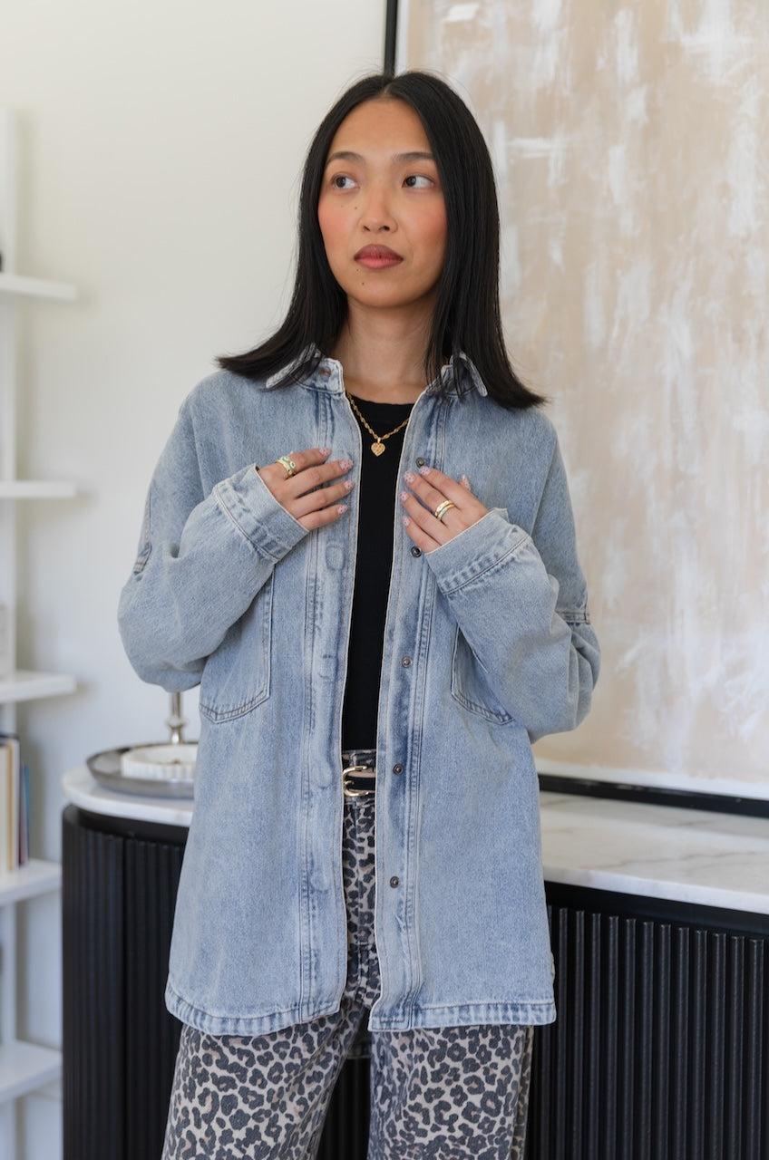 Woman wearing a light blue denim jacket in an indoor setting
