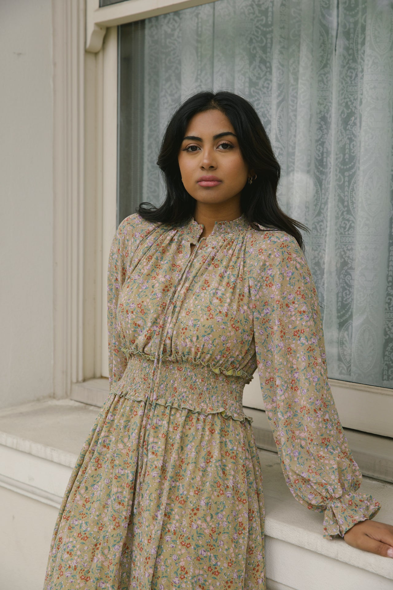 green floral midi dress with long sleeves and a smocked waistline
