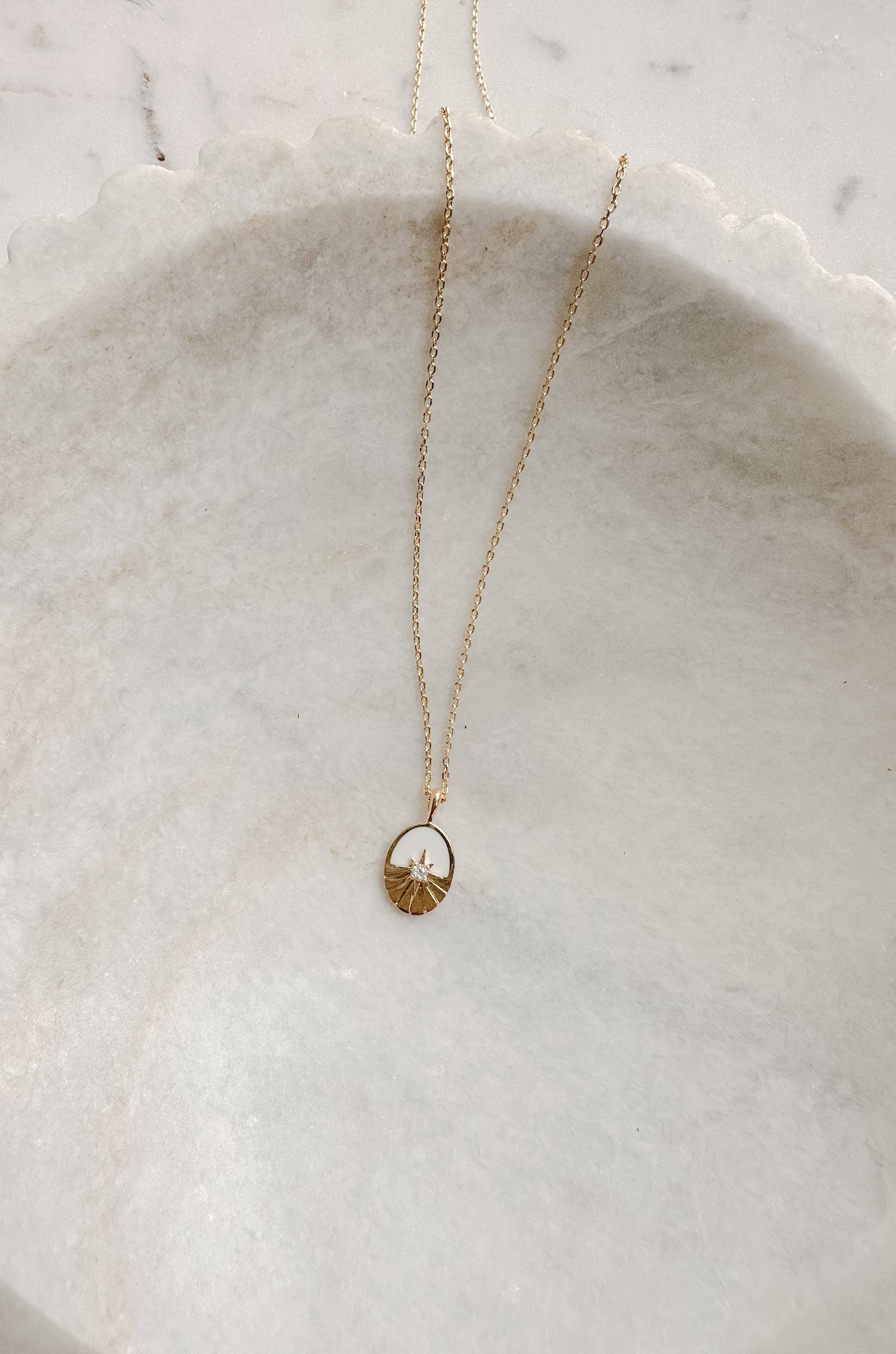 oval pendant necklace with a sun rhinestone detail on a 18k gold chain