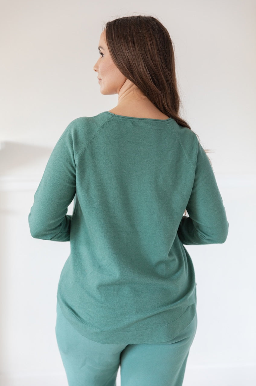 Woman wearing a green Pullover Sweater Long Sleeve Knit Top with a boat neckline