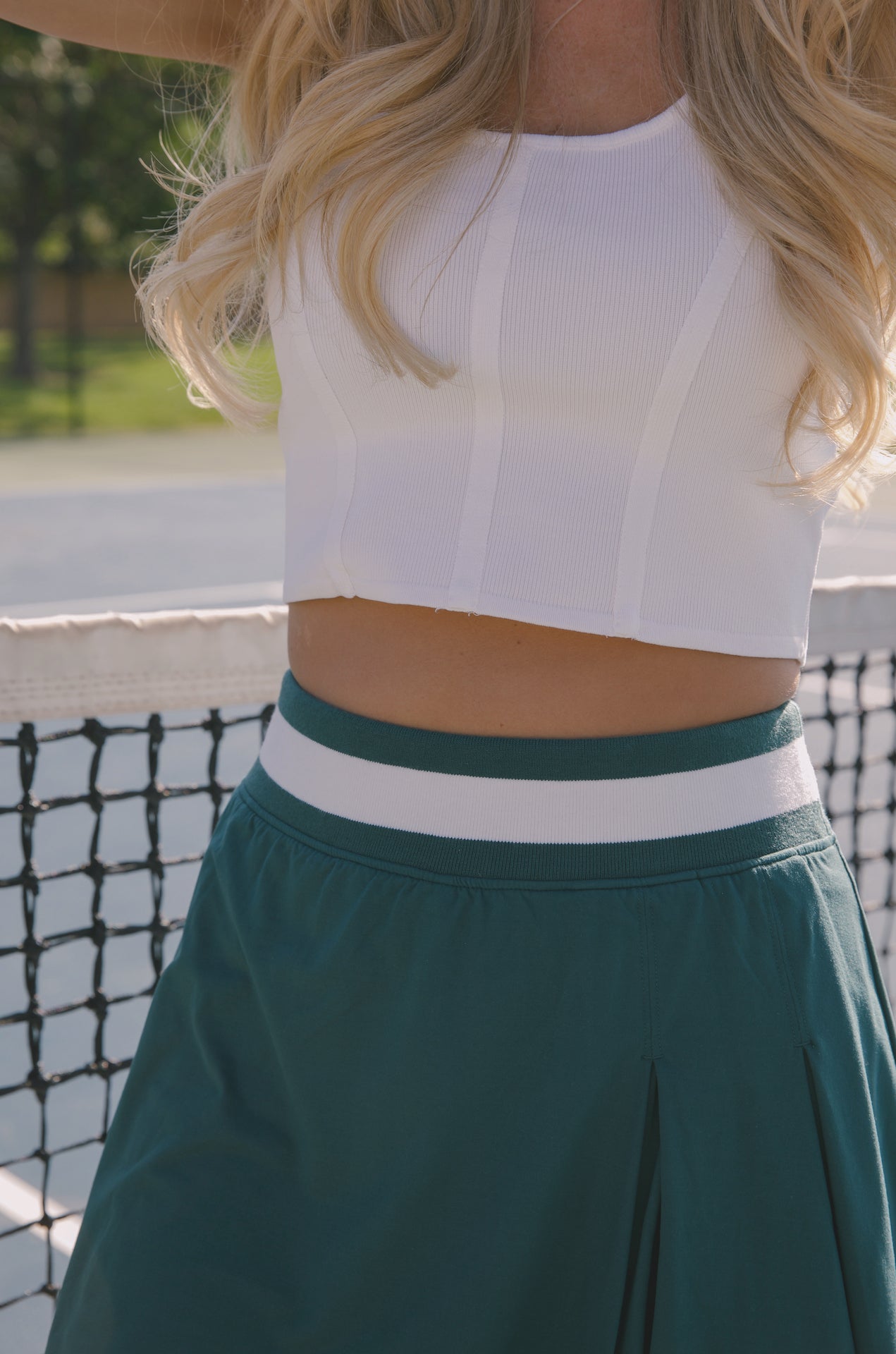 green pleated mini skirt with stretchy waist band worn for pickleball, tennis and golf