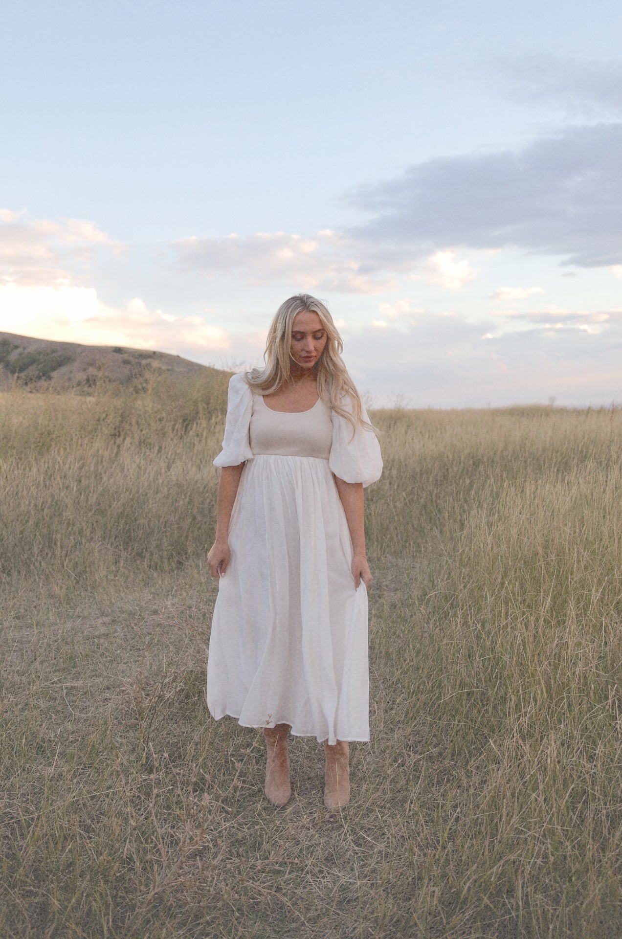 cream and white puff sleeve midi dress with a babydoll silhouette