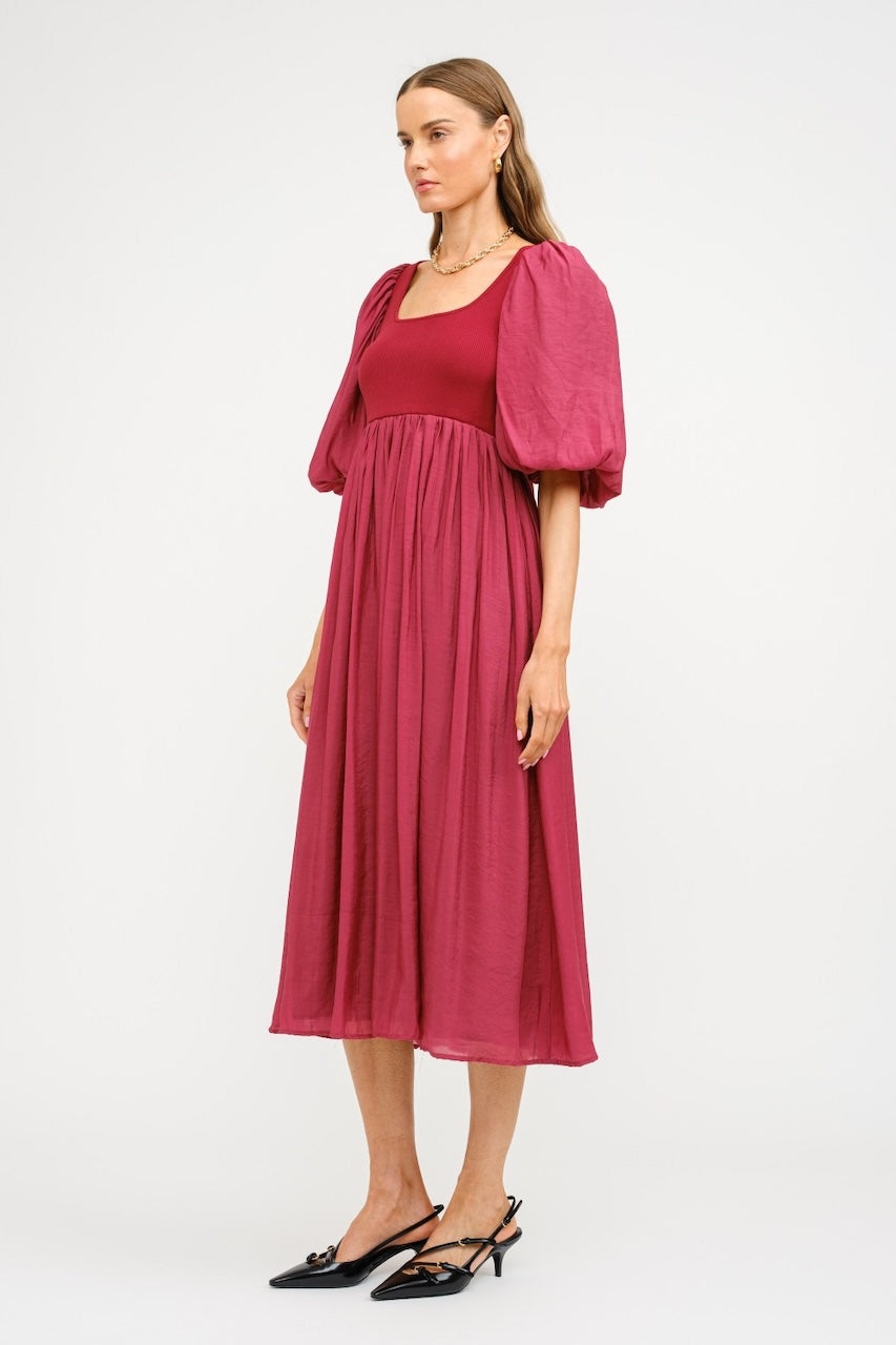Woman wearing a pink dress with matching bolero on a white background