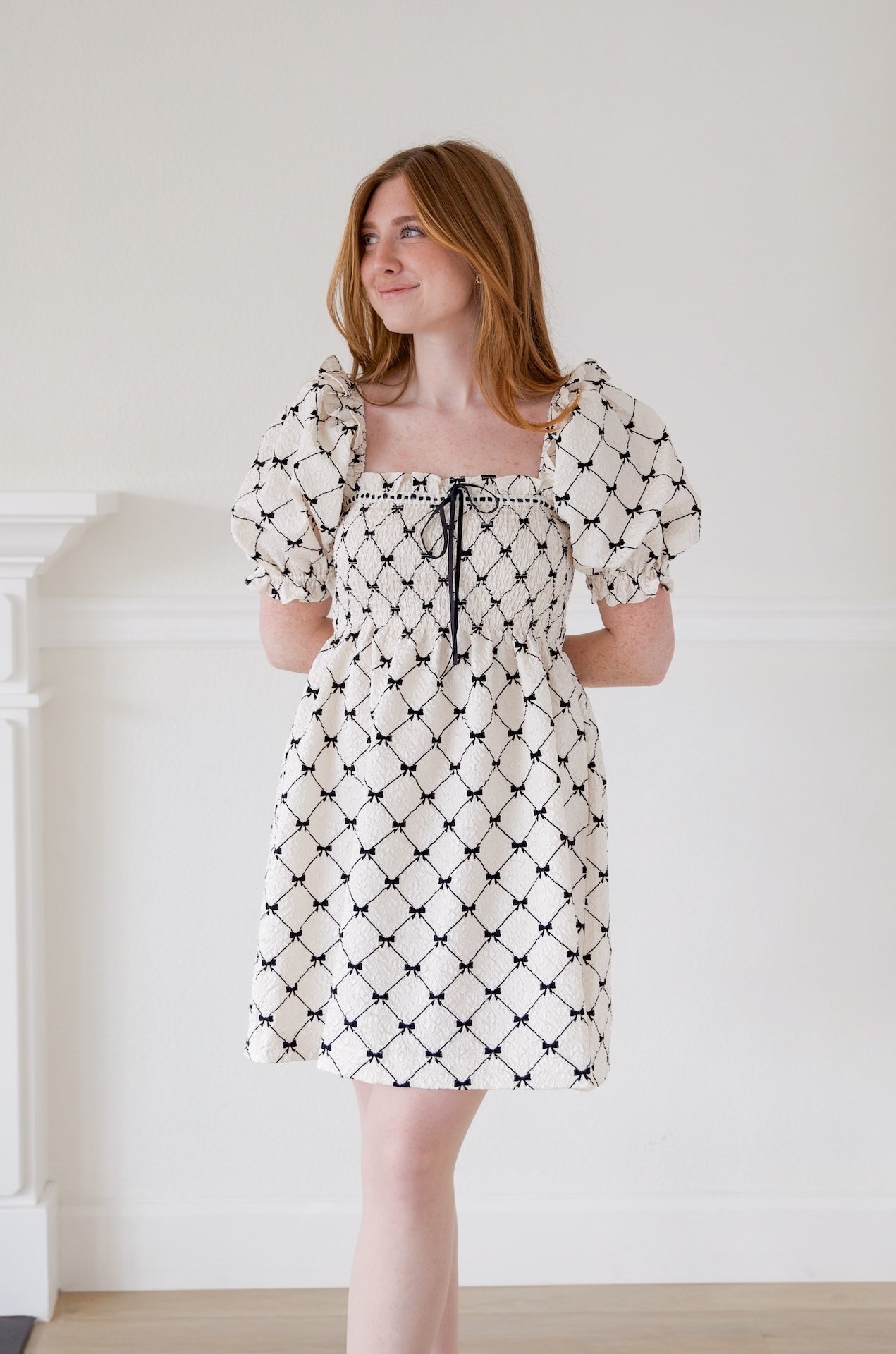 black and ivory babydoll puff sleeve mini dress with bows printed all over