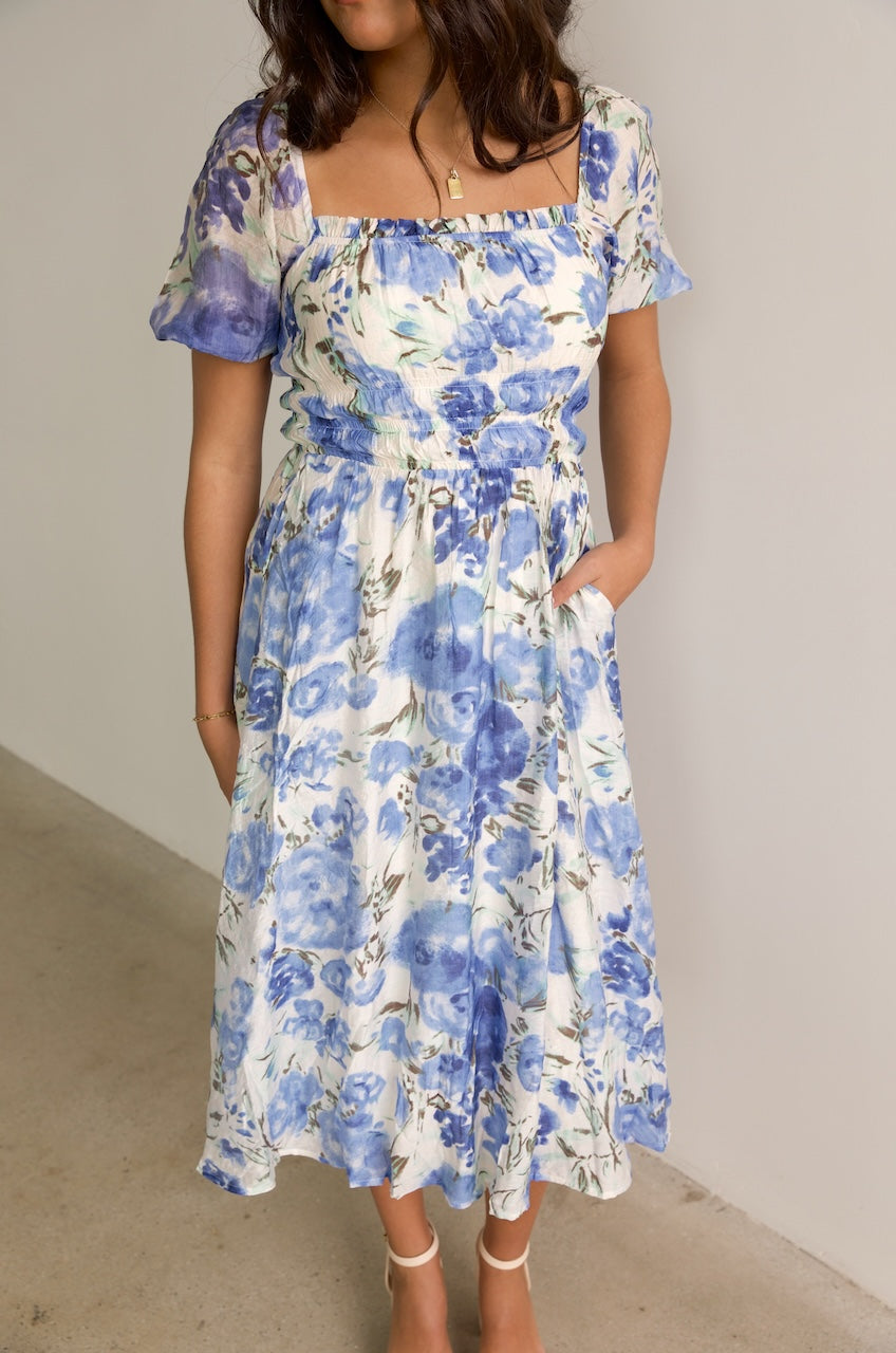 blue and white floral midi dress with puff sleeves and a square neckline
