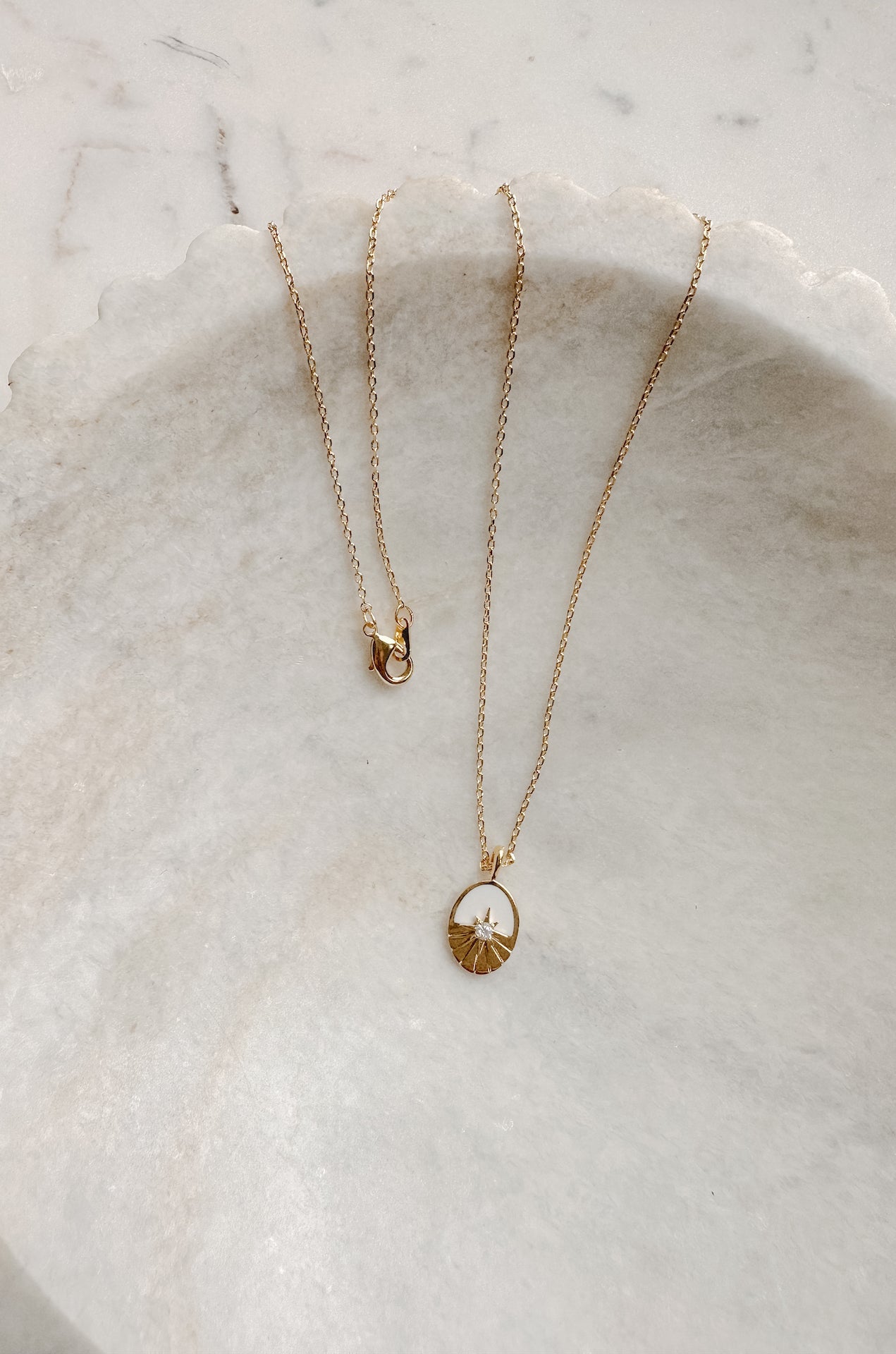 oval pendant necklace with a sun rhinestone detail on a 18k gold chain