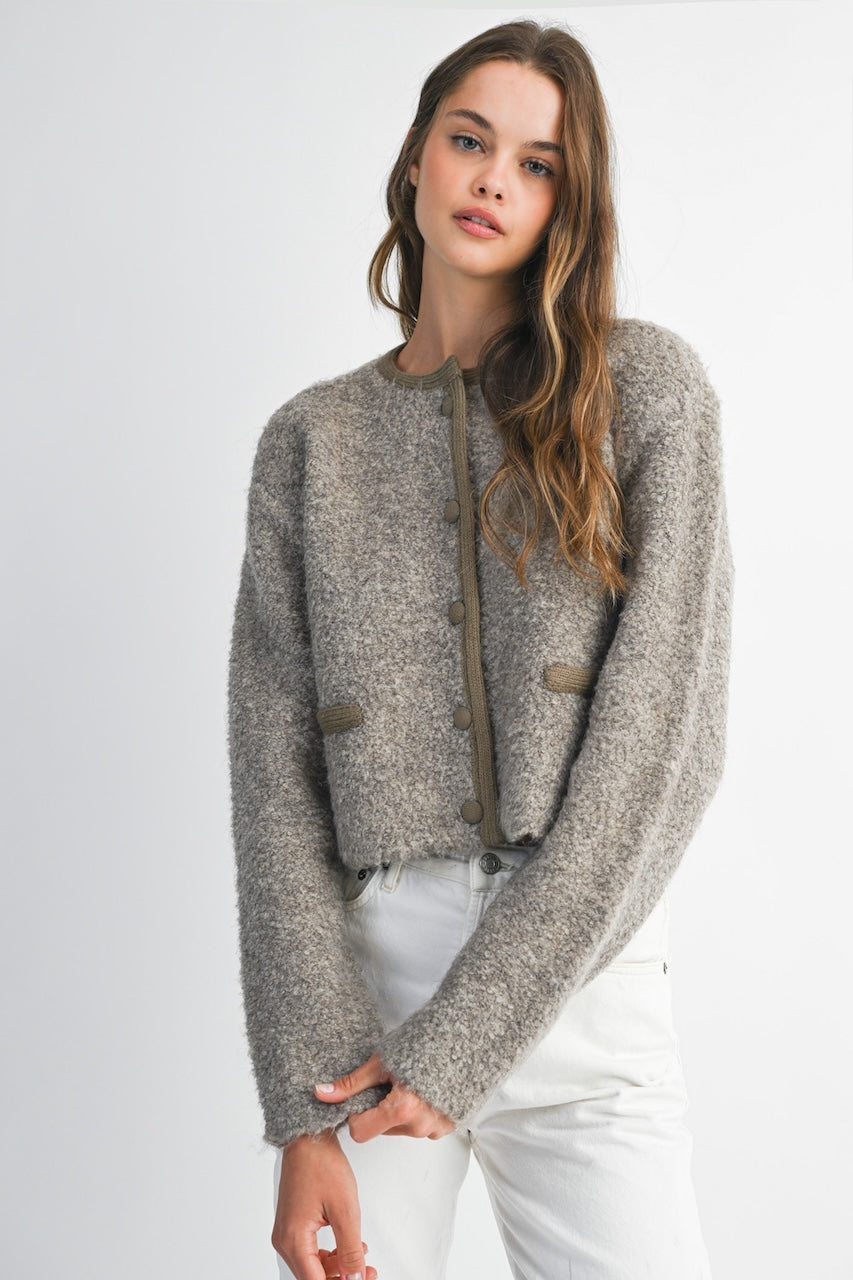 Woman wearing a brown knitted texture boucle jacket with brown buttons