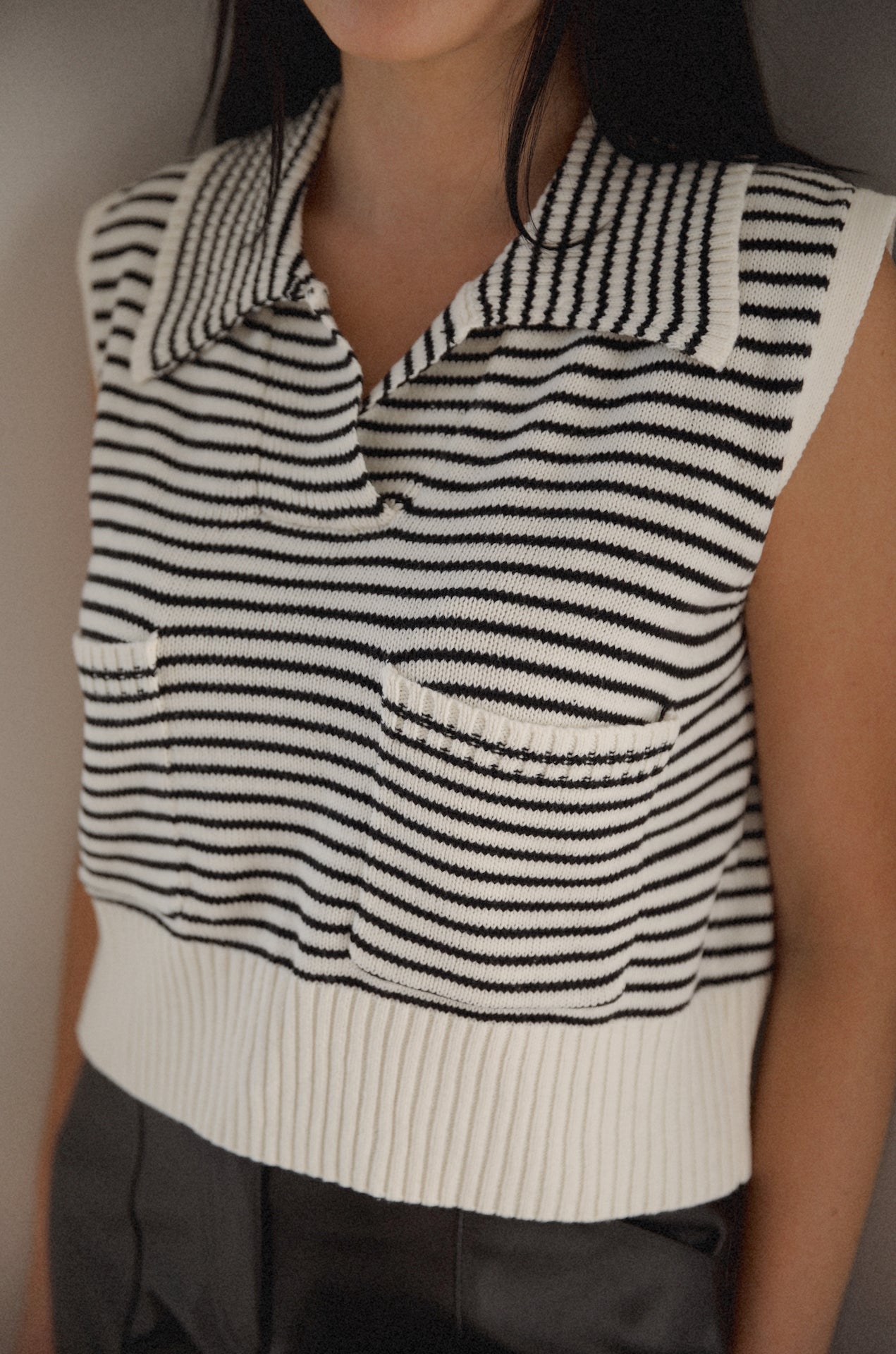 black and white striped sweater vest that is collared with pockets