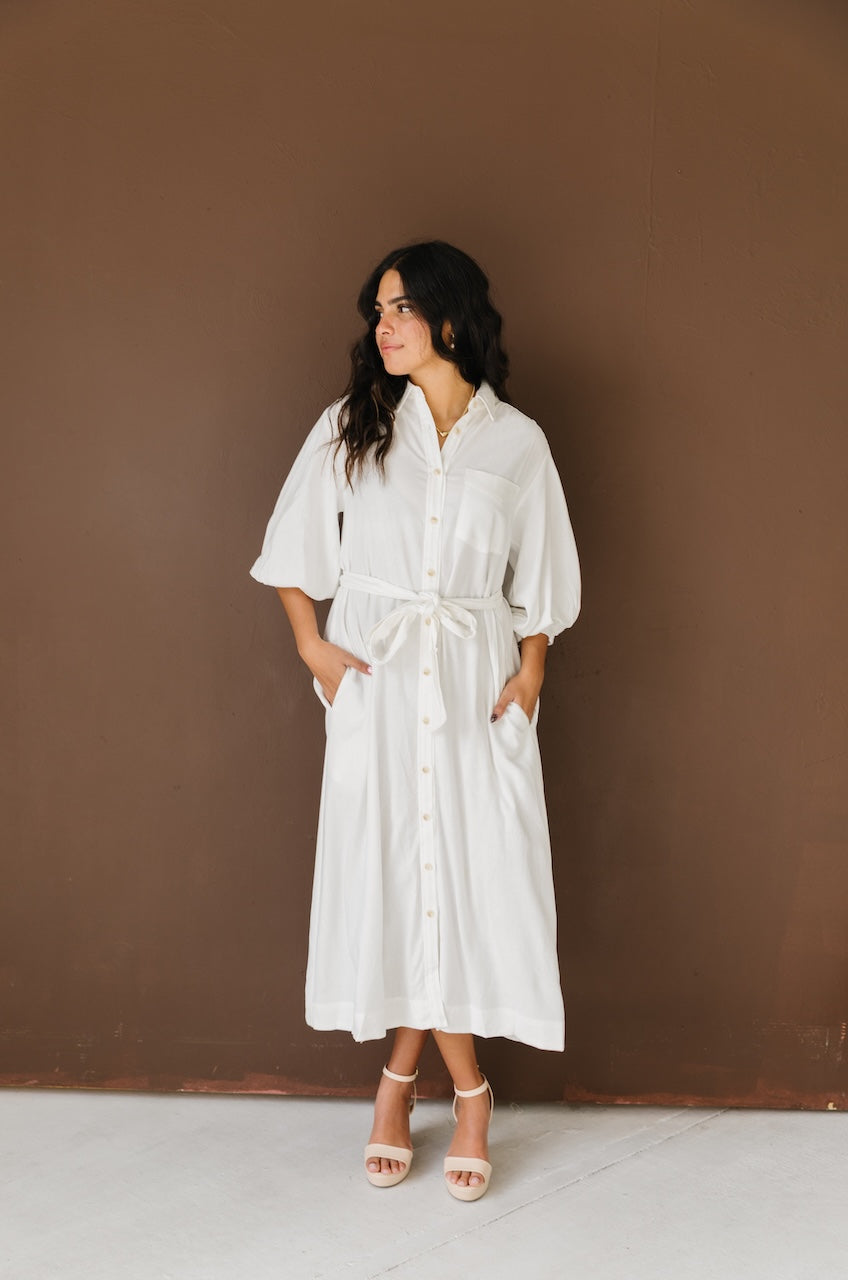 Woman wearing a white linen button down with belt midi dress