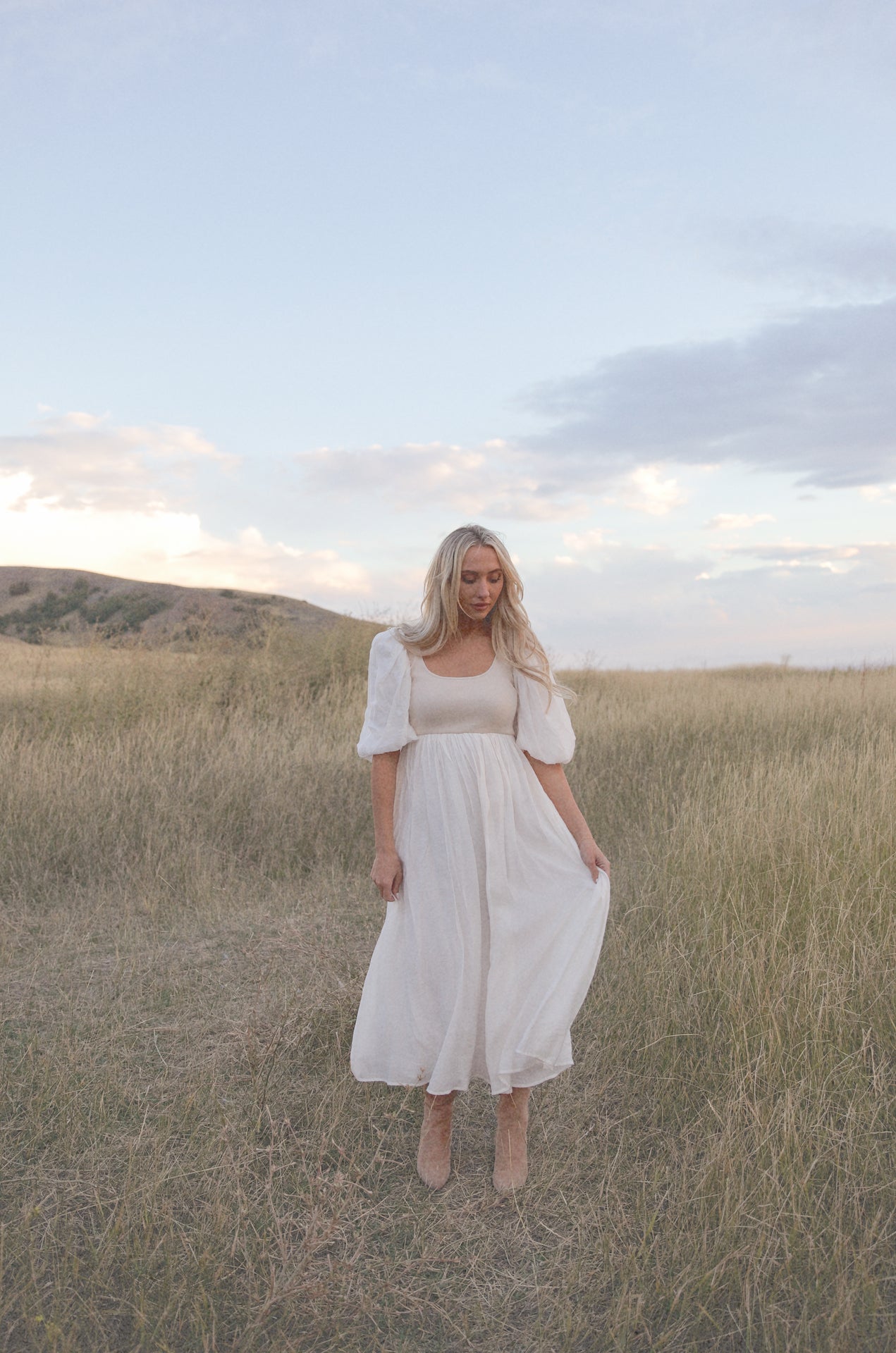 cream and white puff sleeve midi dress with a babydoll silhouette