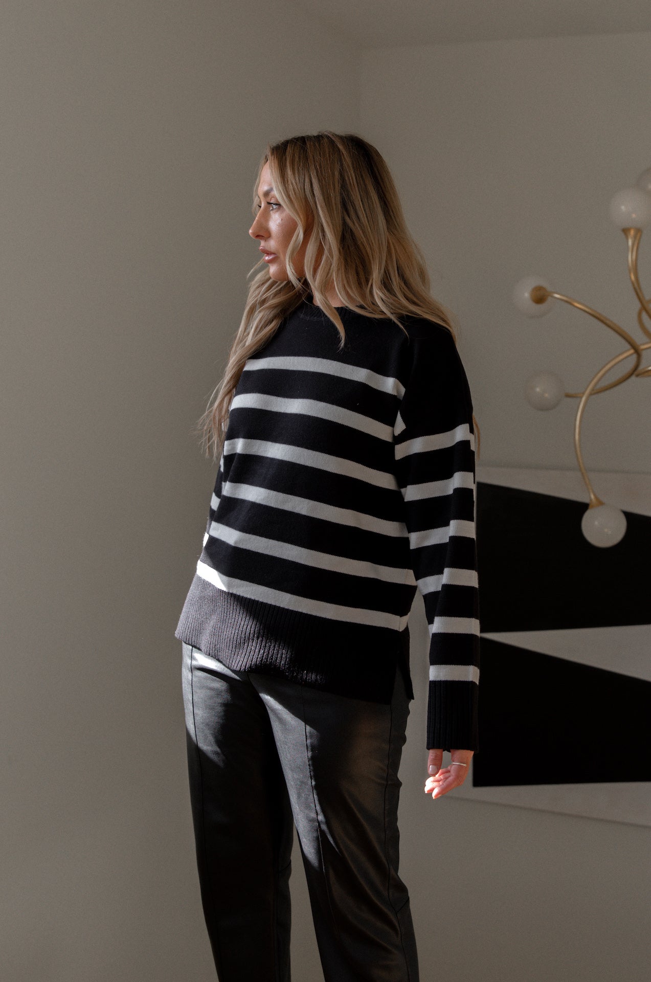 black and cream striped sweater with a round neckline and side slits