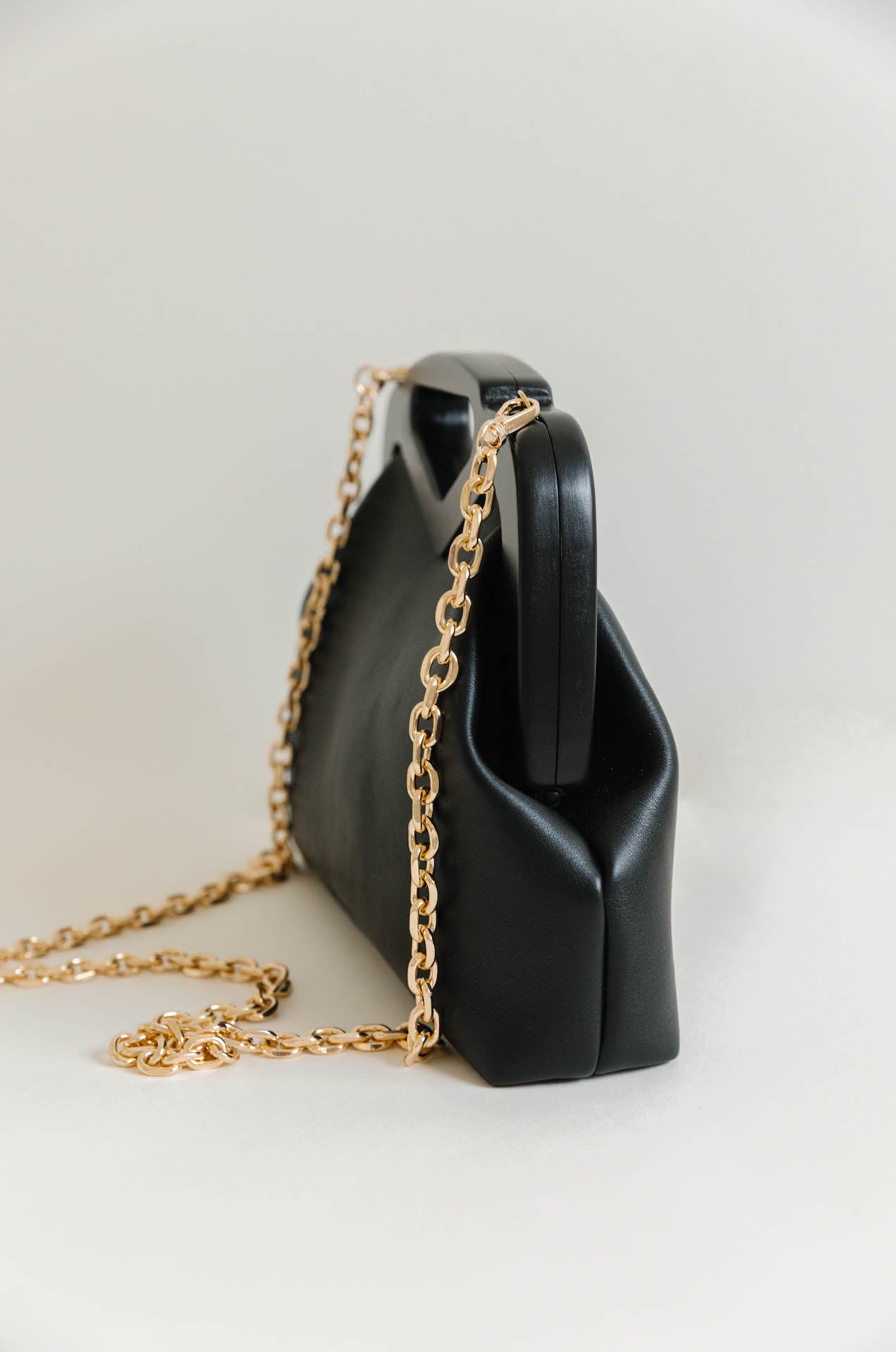 black vegan leather triangle top handle bag with gold chain