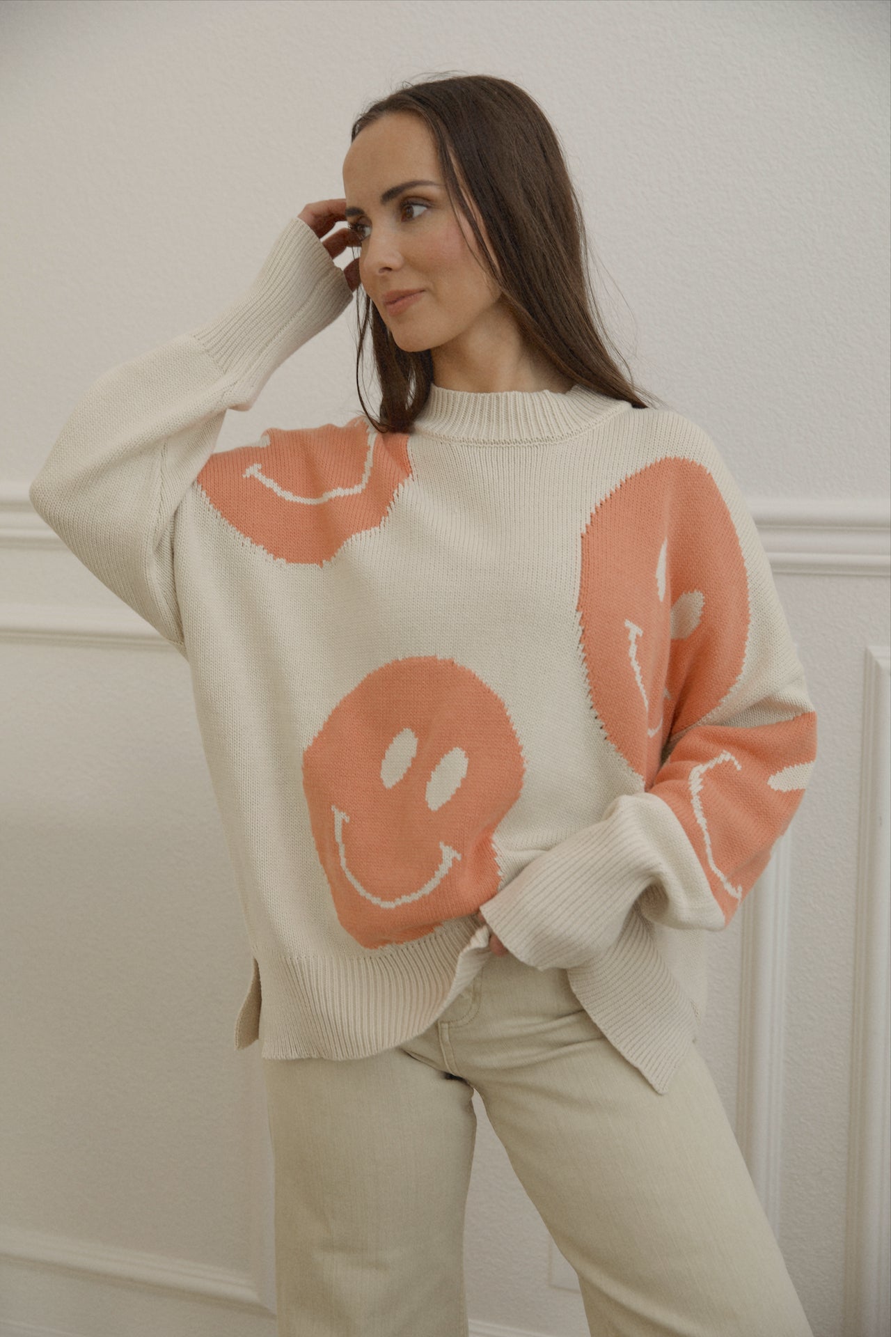 orange smiley face sweater with a mock neckline and an oversized fit