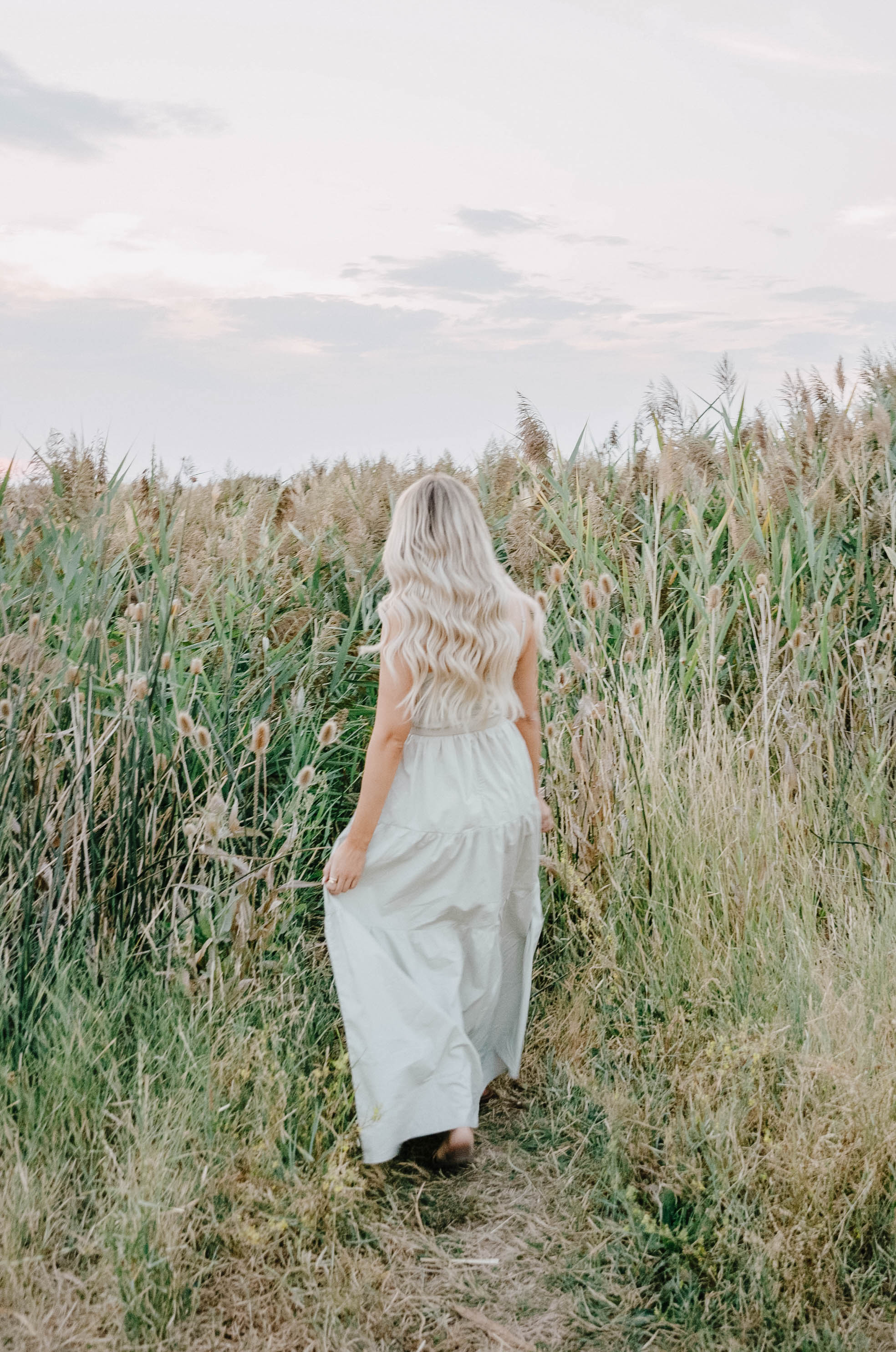 long blonde curly hair in a sage maxi dress