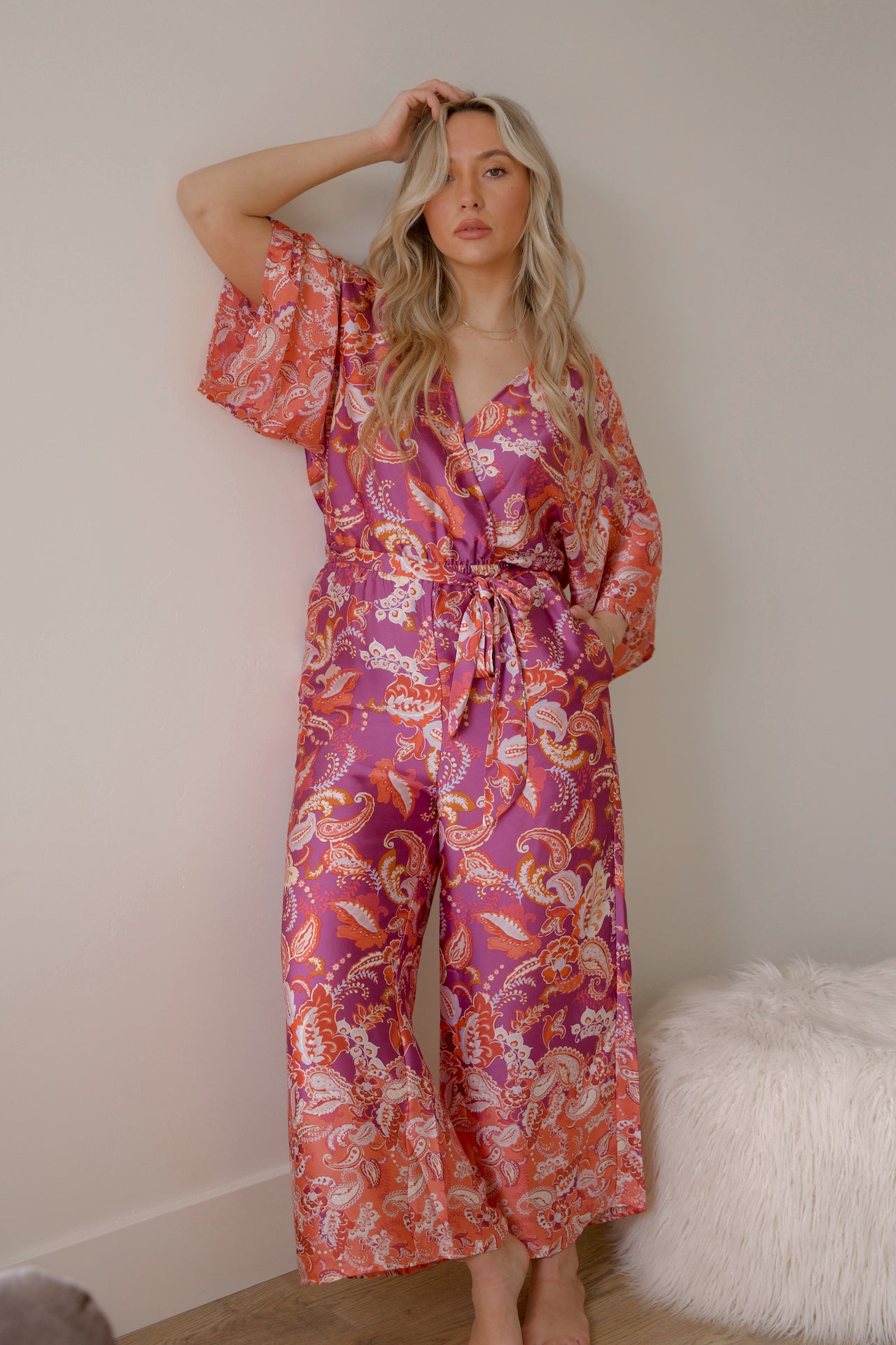pink and purple printed paisley jumpsuit with long sleeves and wide leg