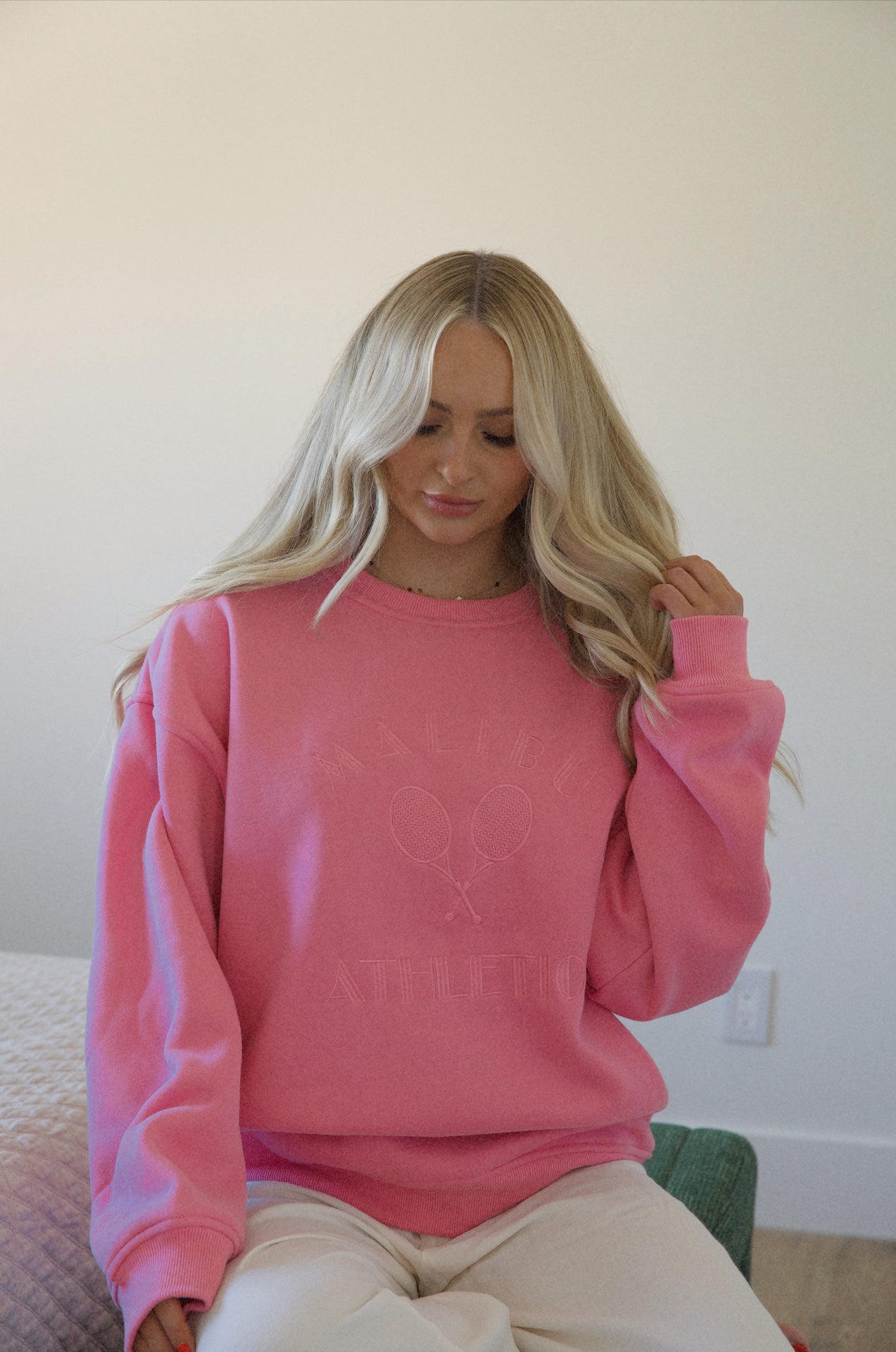 pink maliA woman wearing a pink Malibu athletics embroidered graphic sweatshirt crew neck pullover that is a preppy fleece sweatshirtbu athletics sweatshirt crew neck pullover