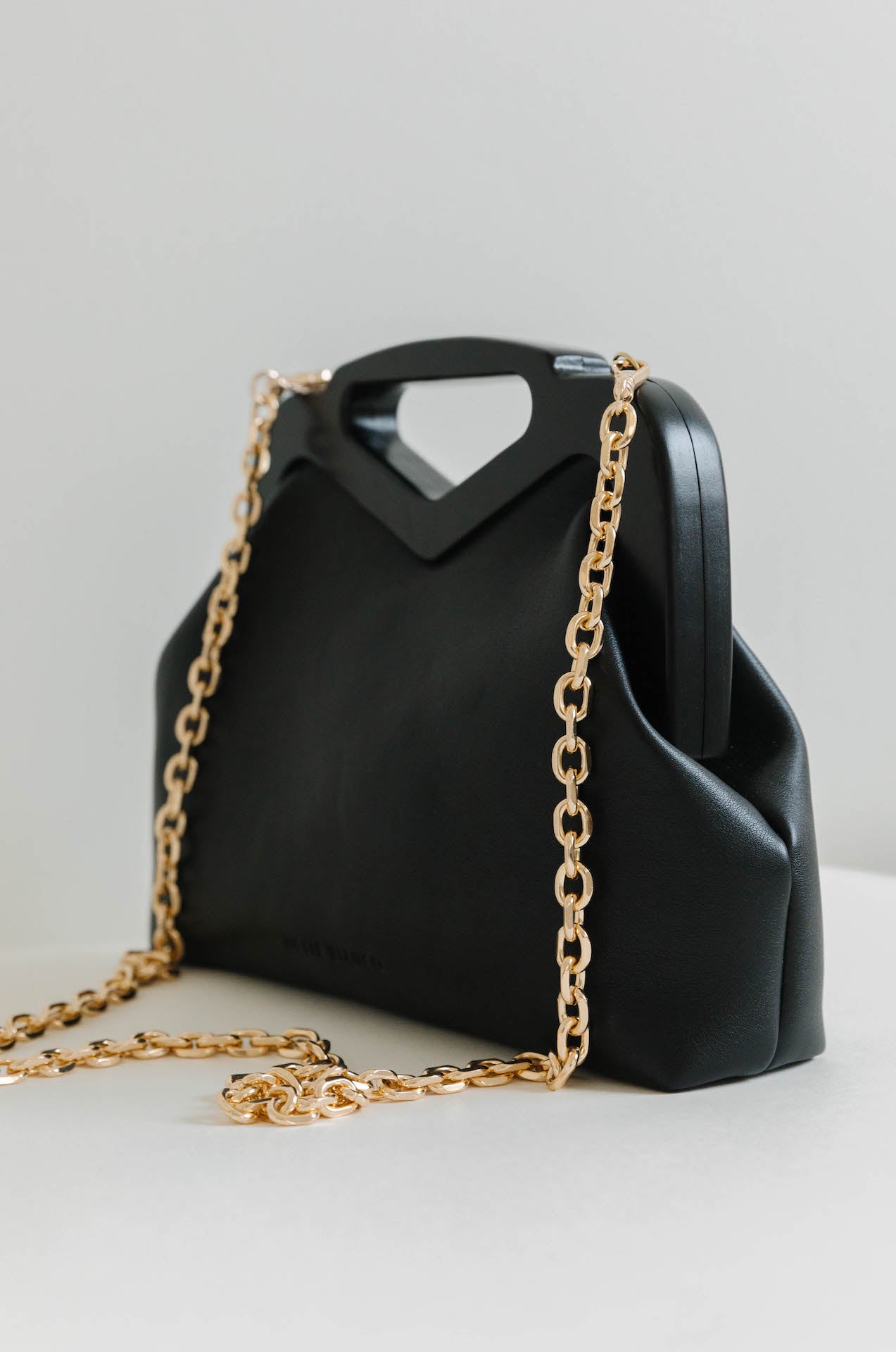 black vegan leather triangle top handle bag