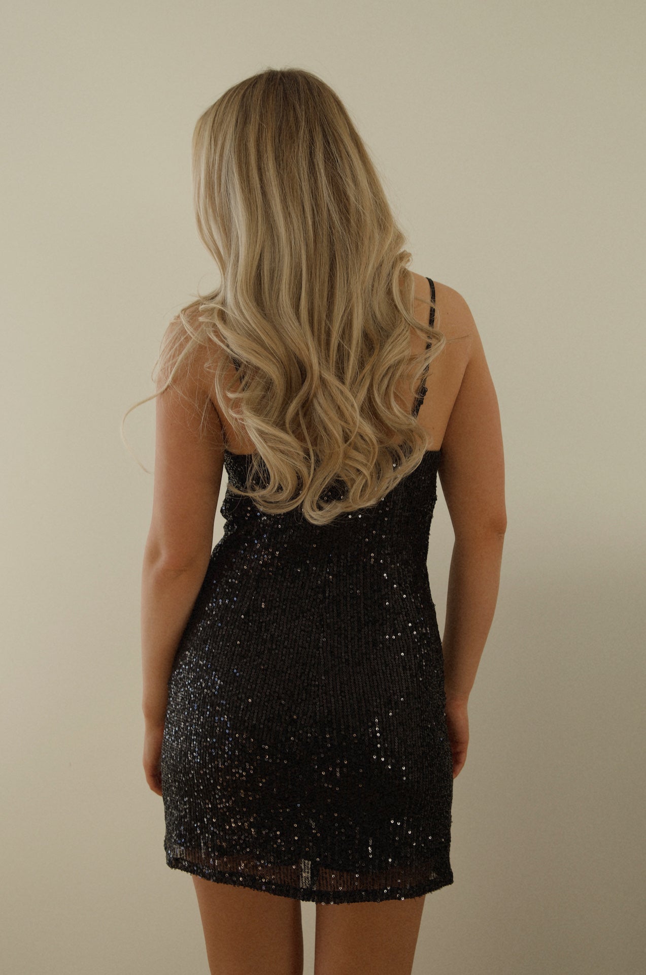 black sequin mini dress with a draped cowl neckline and spaghetti straps