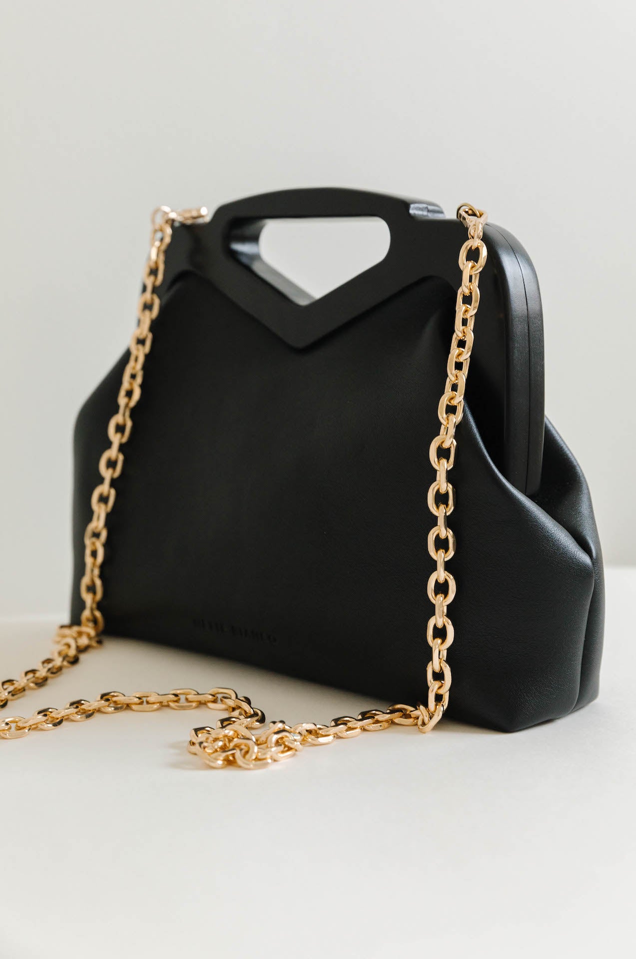 black vegan leather triangle top handle bag
