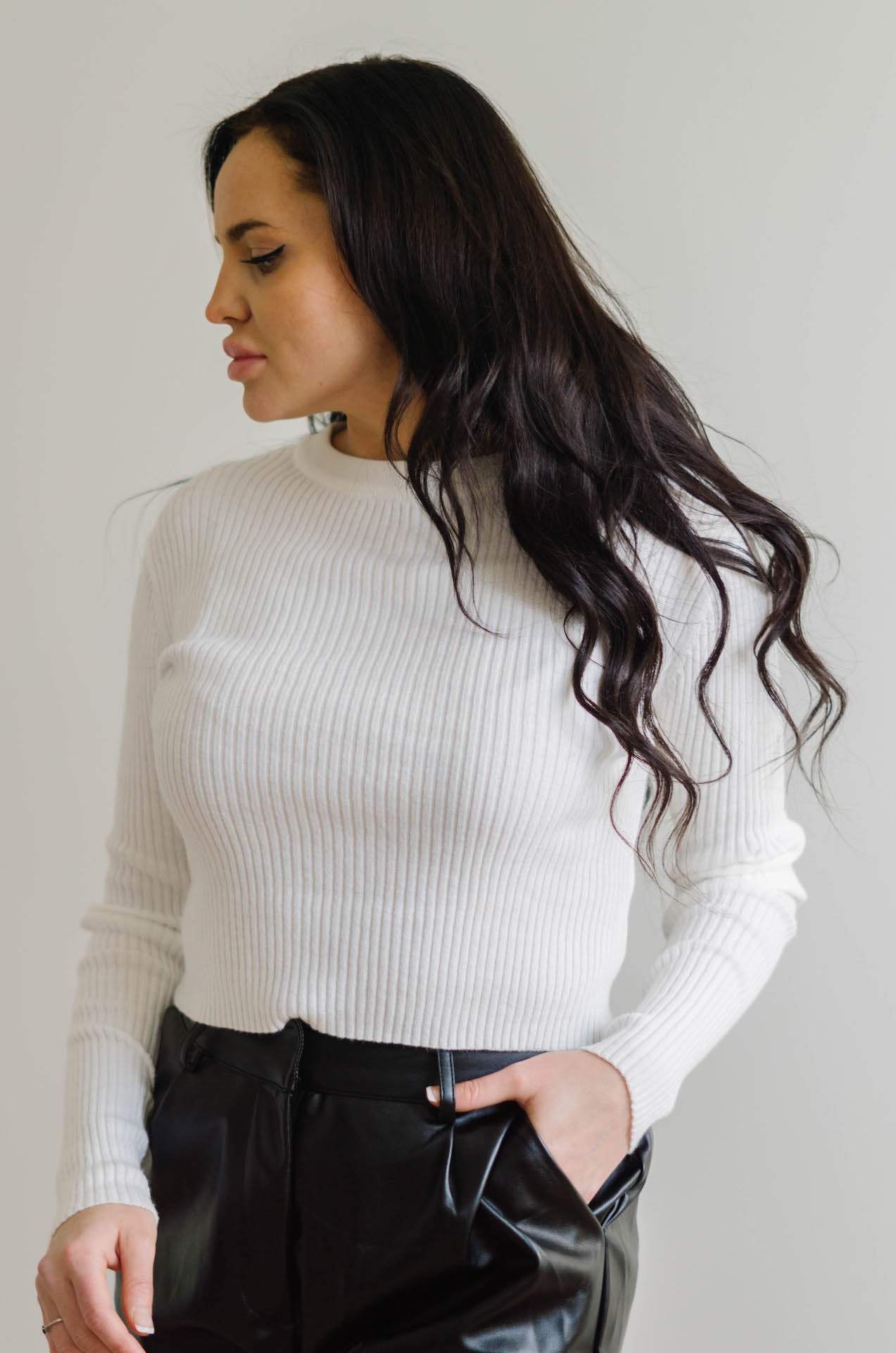 white ribbed sweater with long sleeves and a crew neck