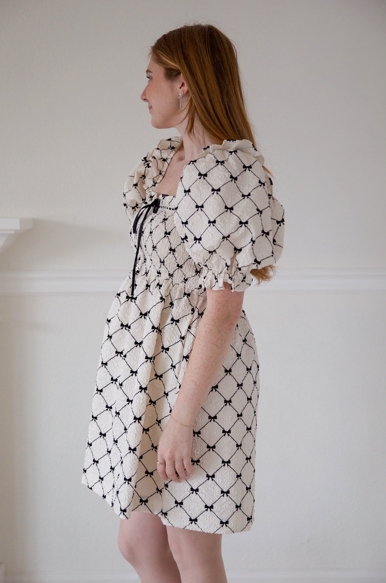 black and ivory babydoll puff sleeve mini dress with bows printed all over