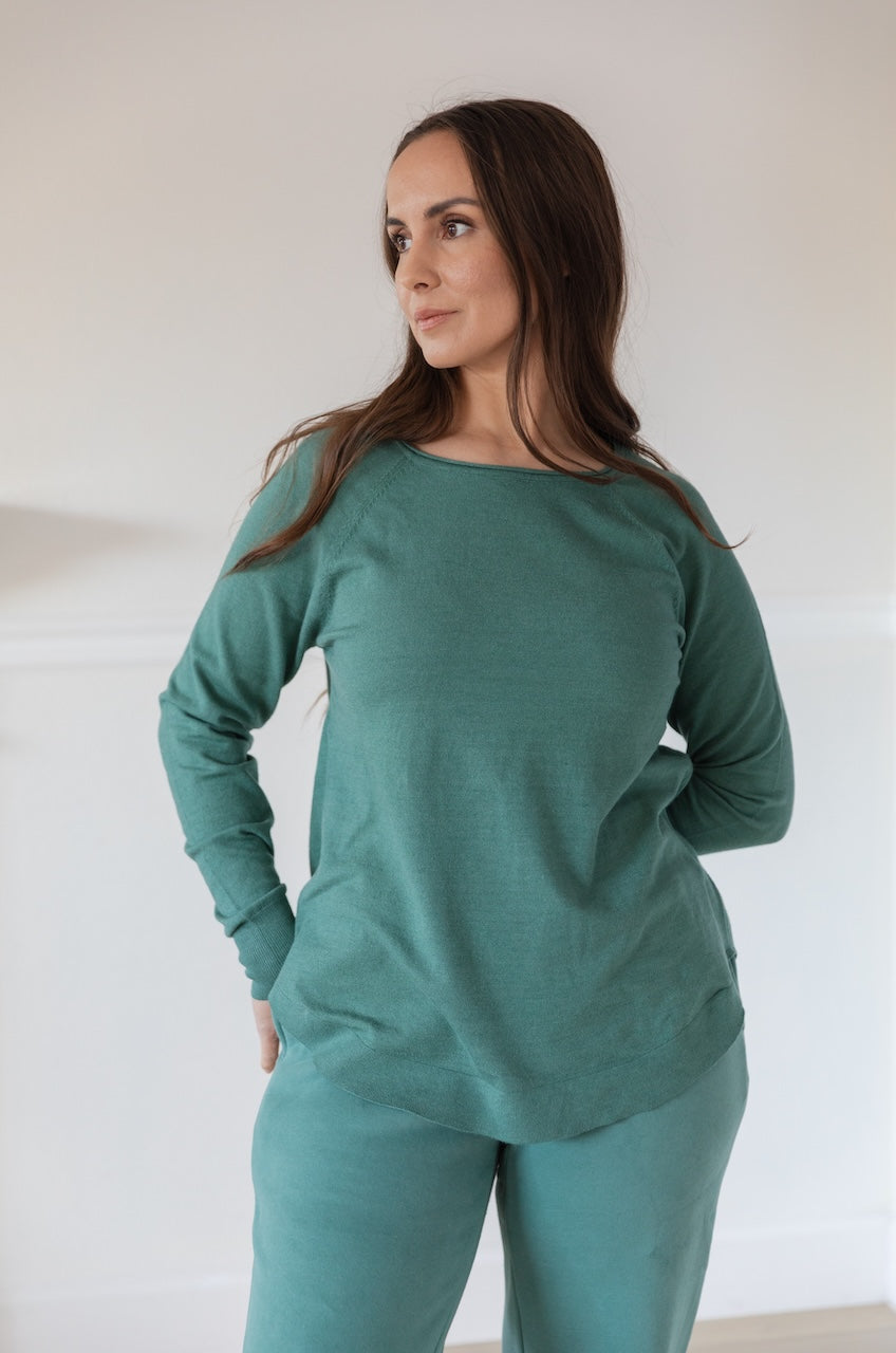 Woman wearing a green Pullover Sweater Long Sleeve Knit Top with a boat neckline