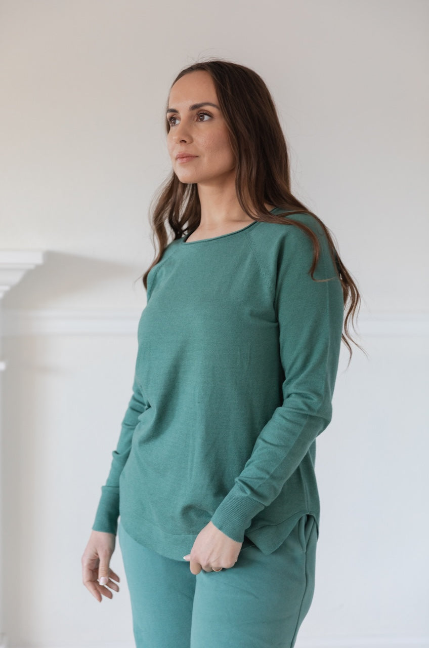 Woman wearing a green Pullover Sweater Long Sleeve Knit Top with a boat neckline