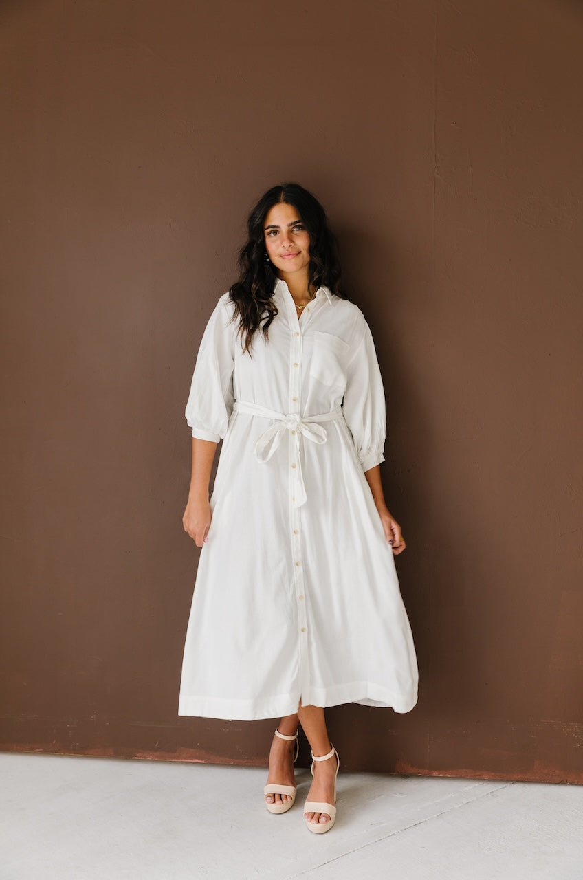 Woman wearing a white linen button down with belt midi dress