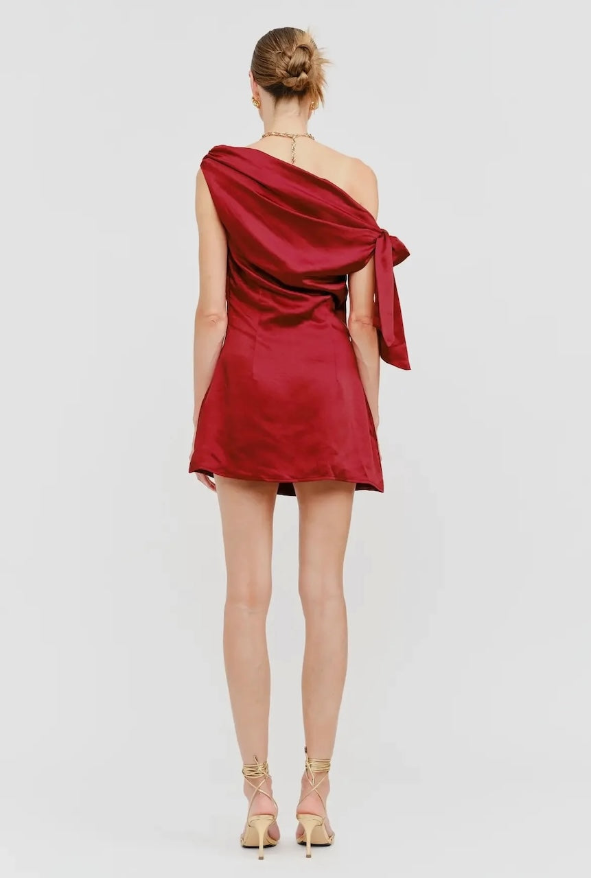 Model wearing red satin one-shoulder mini dress with side bow