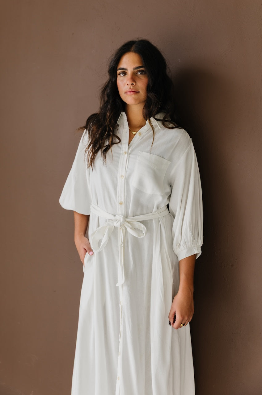Woman wearing a white linen button down with belt midi dress