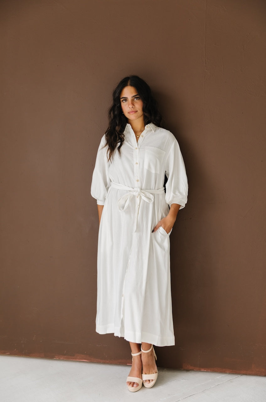 Woman wearing a white linen button down with belt midi dress