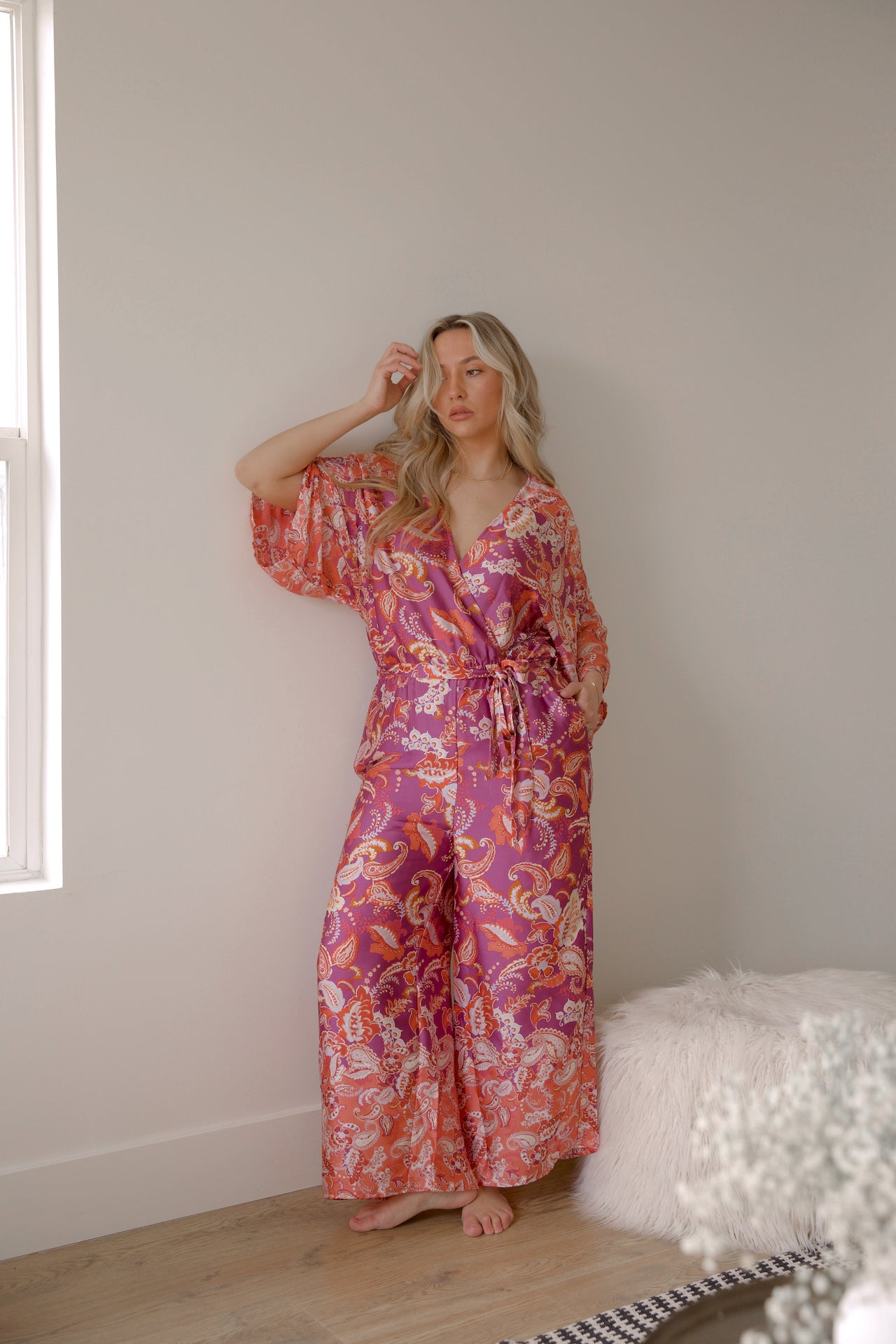 pink and purple printed paisley jumpsuit with long sleeves and wide leg