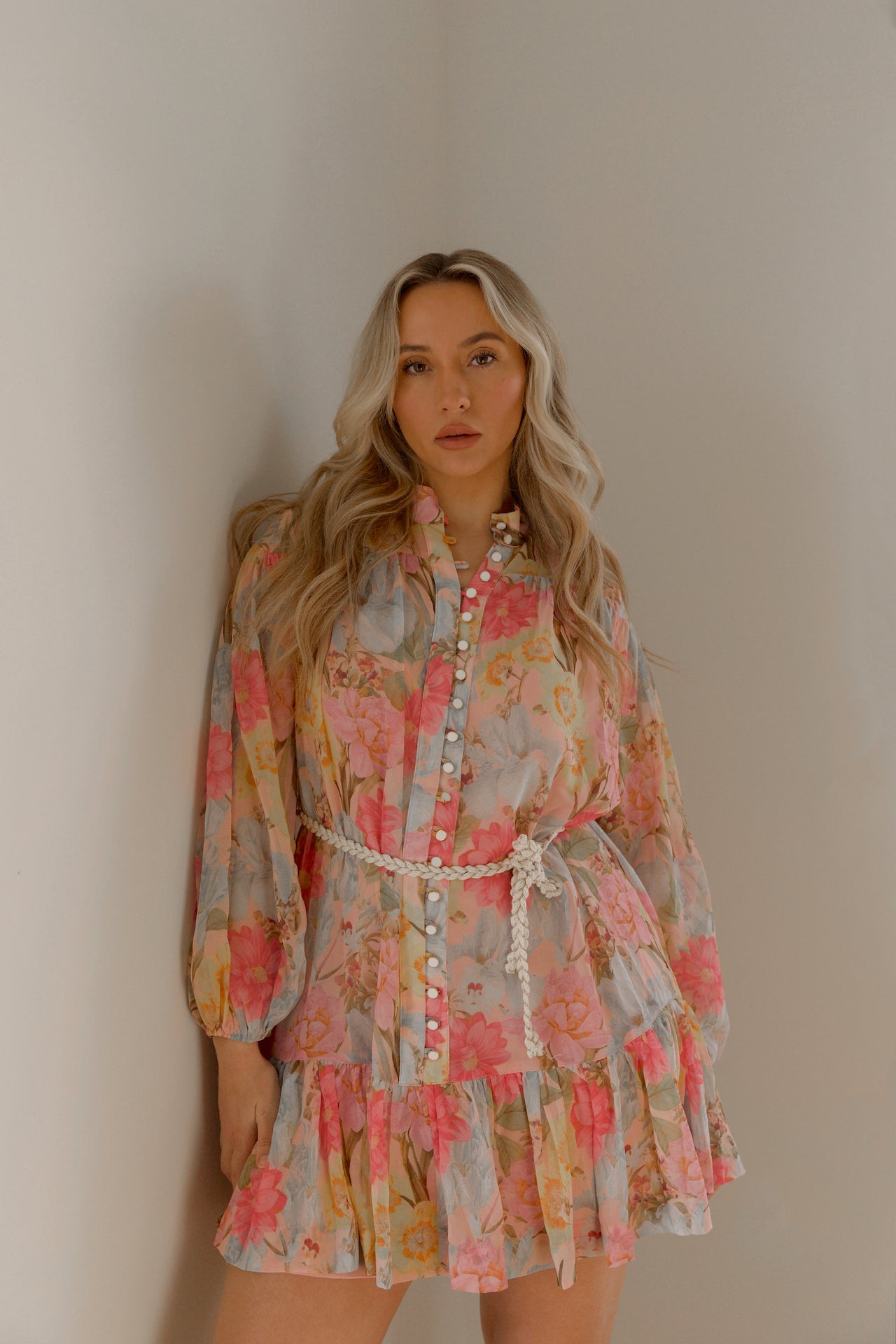 pink and blue floral sheer mini dress with long sleeves and a braided waist tie