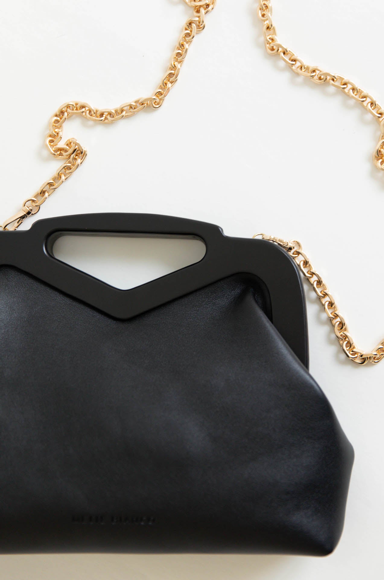 black vegan leather triangle top handle bag with gold chain