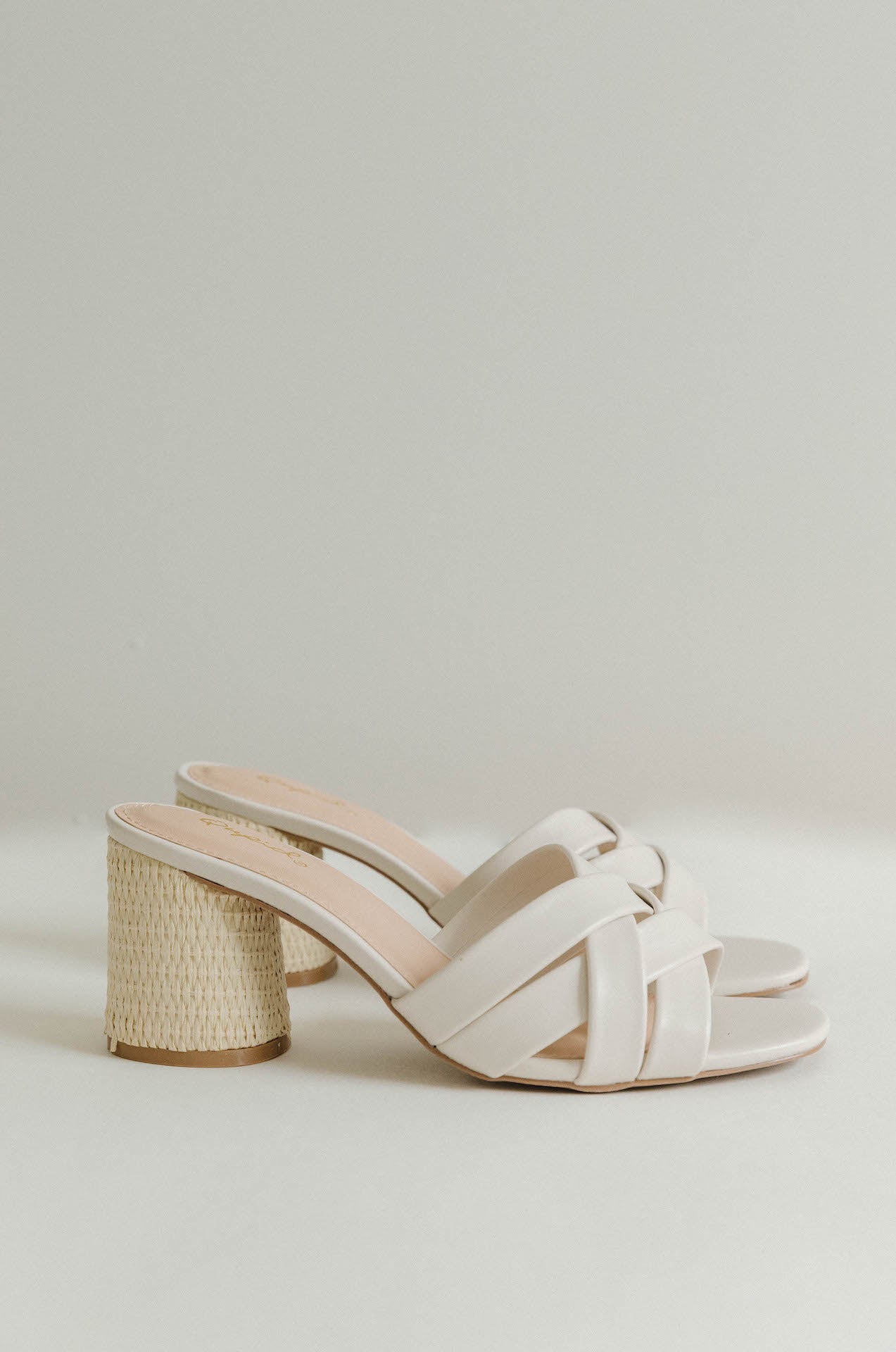 white leather woven heels with a chunky raffia heel
